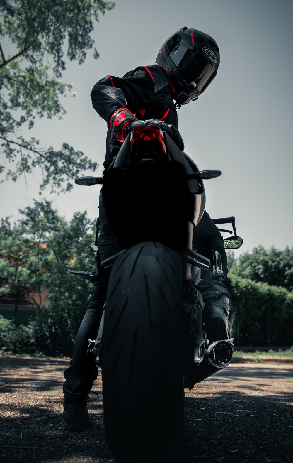 man in black leather jacket riding black motorcycle photo