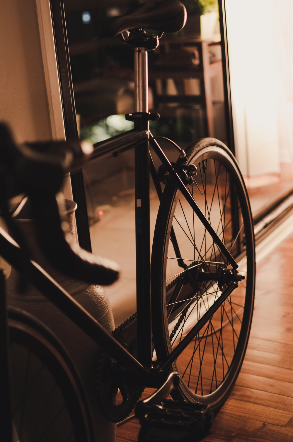 grayscale photo of bicycle near window photo