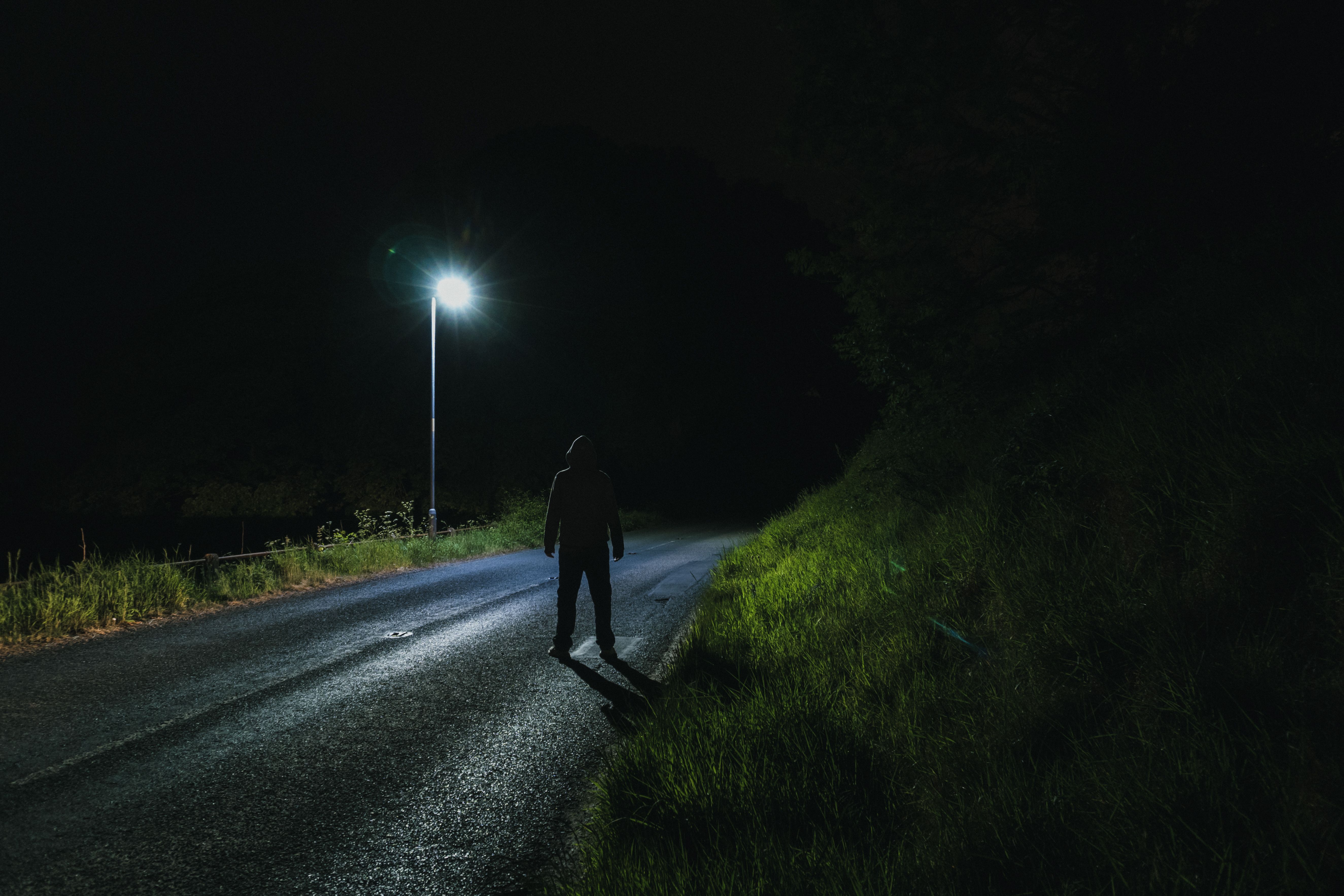 A Sinister Hooded Figure, Looking At A Street Light At Night by Dave Wall. Street light, Night light, Country roads