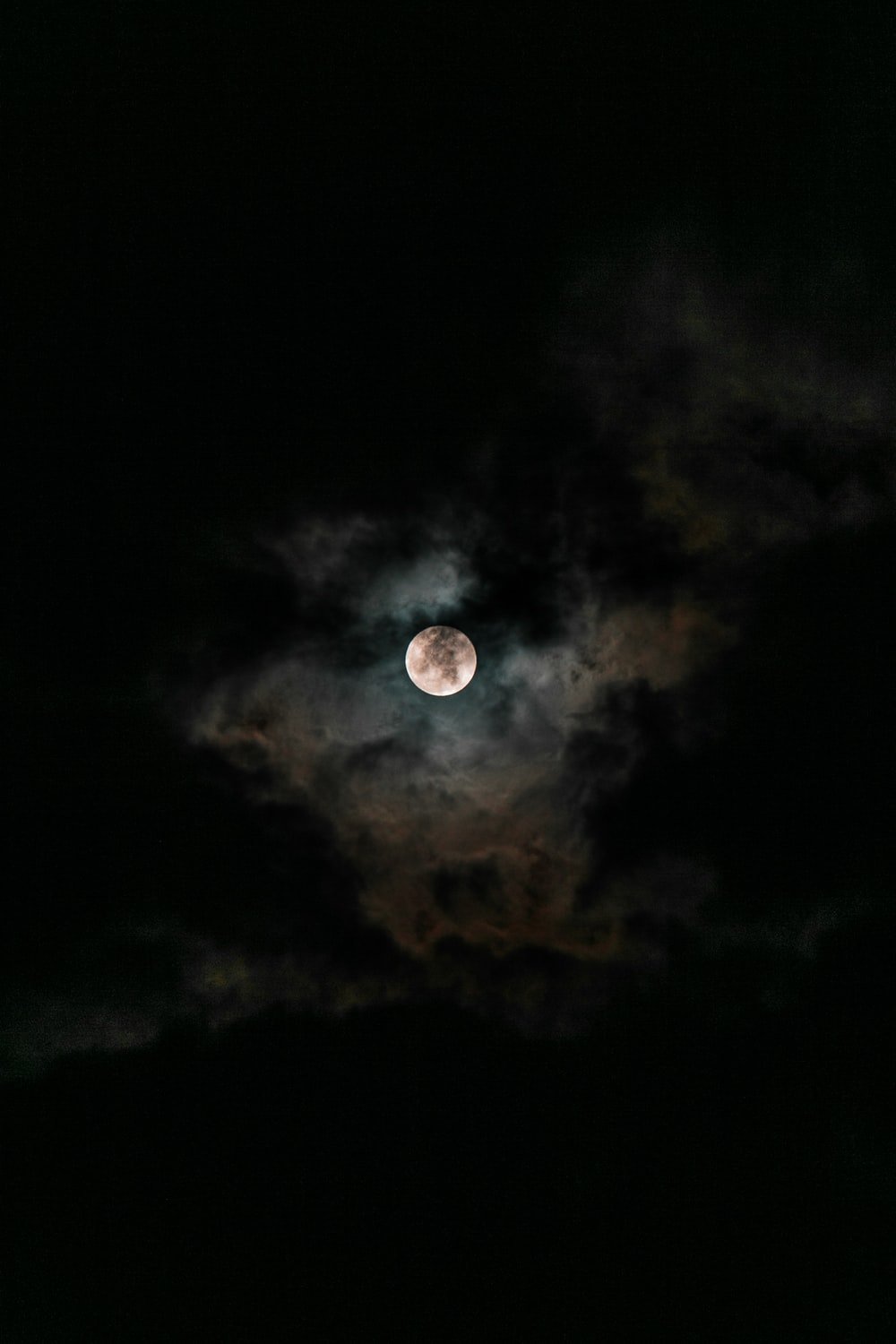 moon covered with clouds at nighttime photo