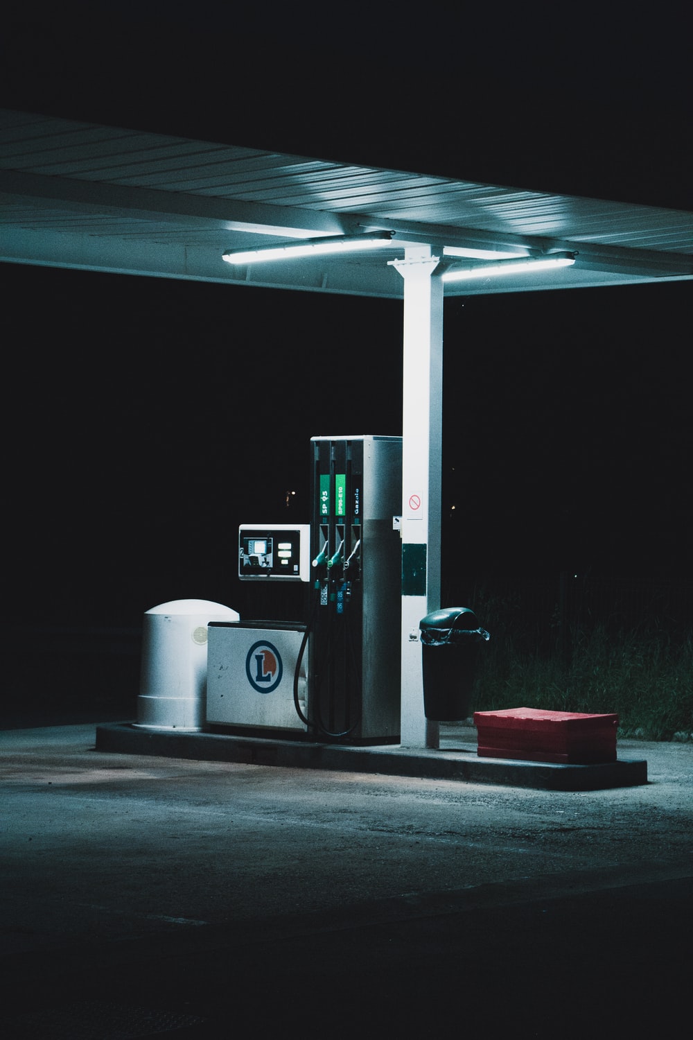 people and cars at the gas station during night photo