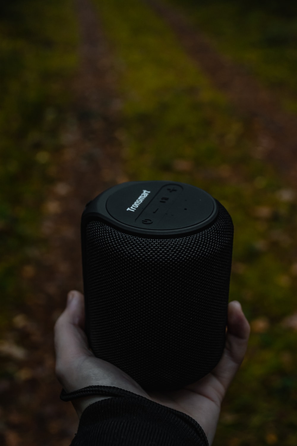 person holding black wireless speaker photo