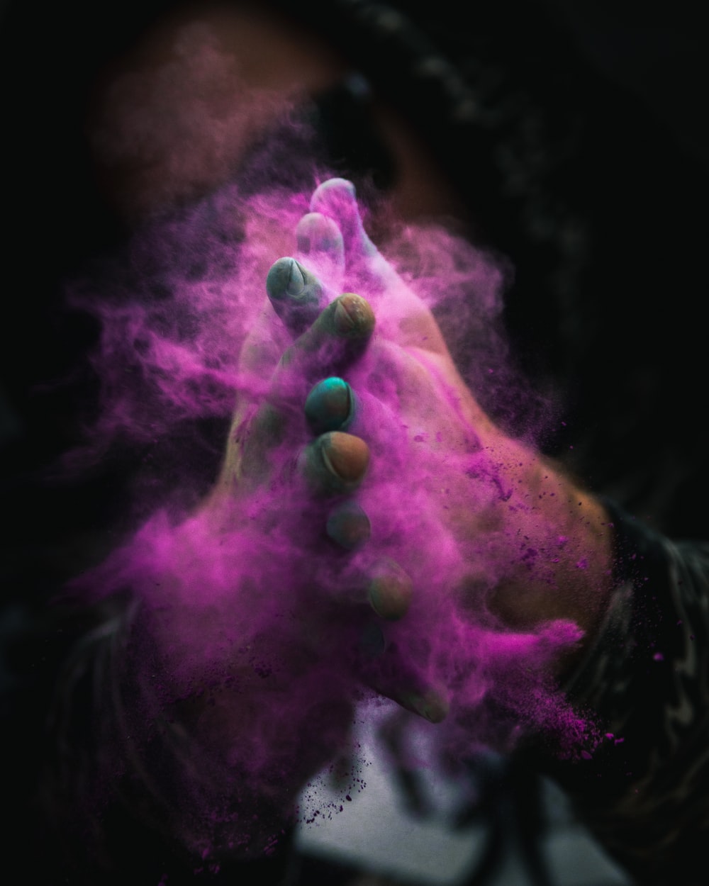 person with colored powders on hands photo