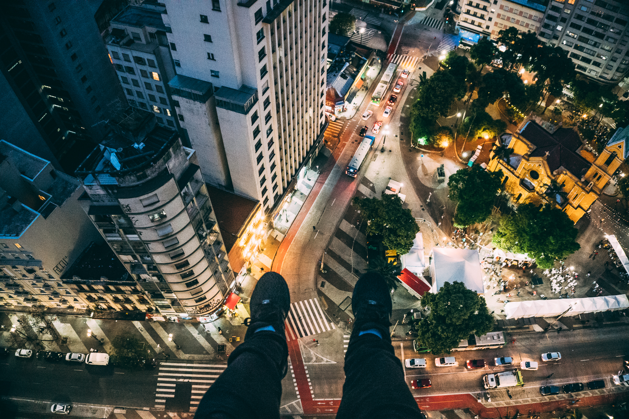 Man Sitting on High Rise Building Taking Photo Below · Free