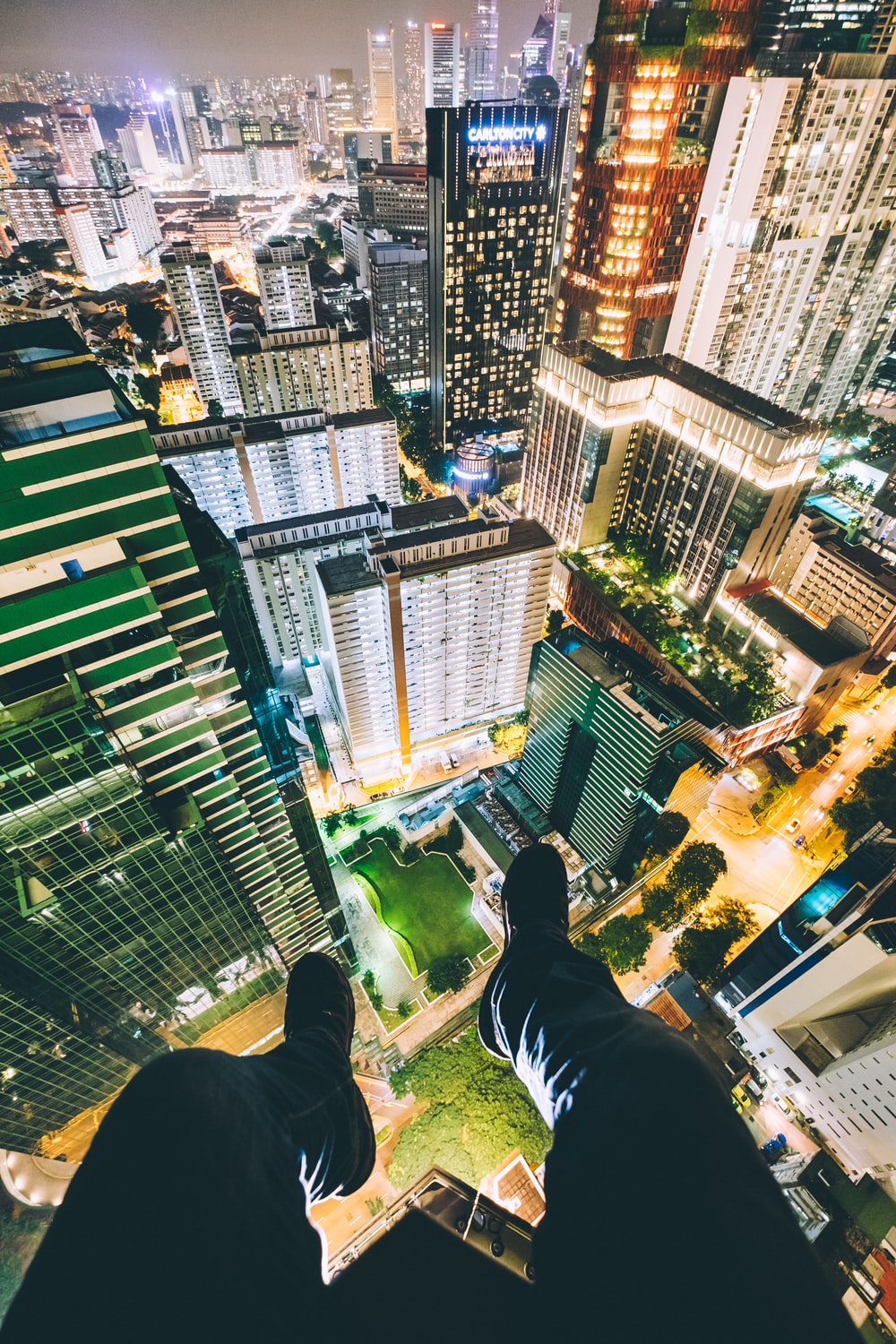 Man Sitting On Top Of High Rise Buildings Photo