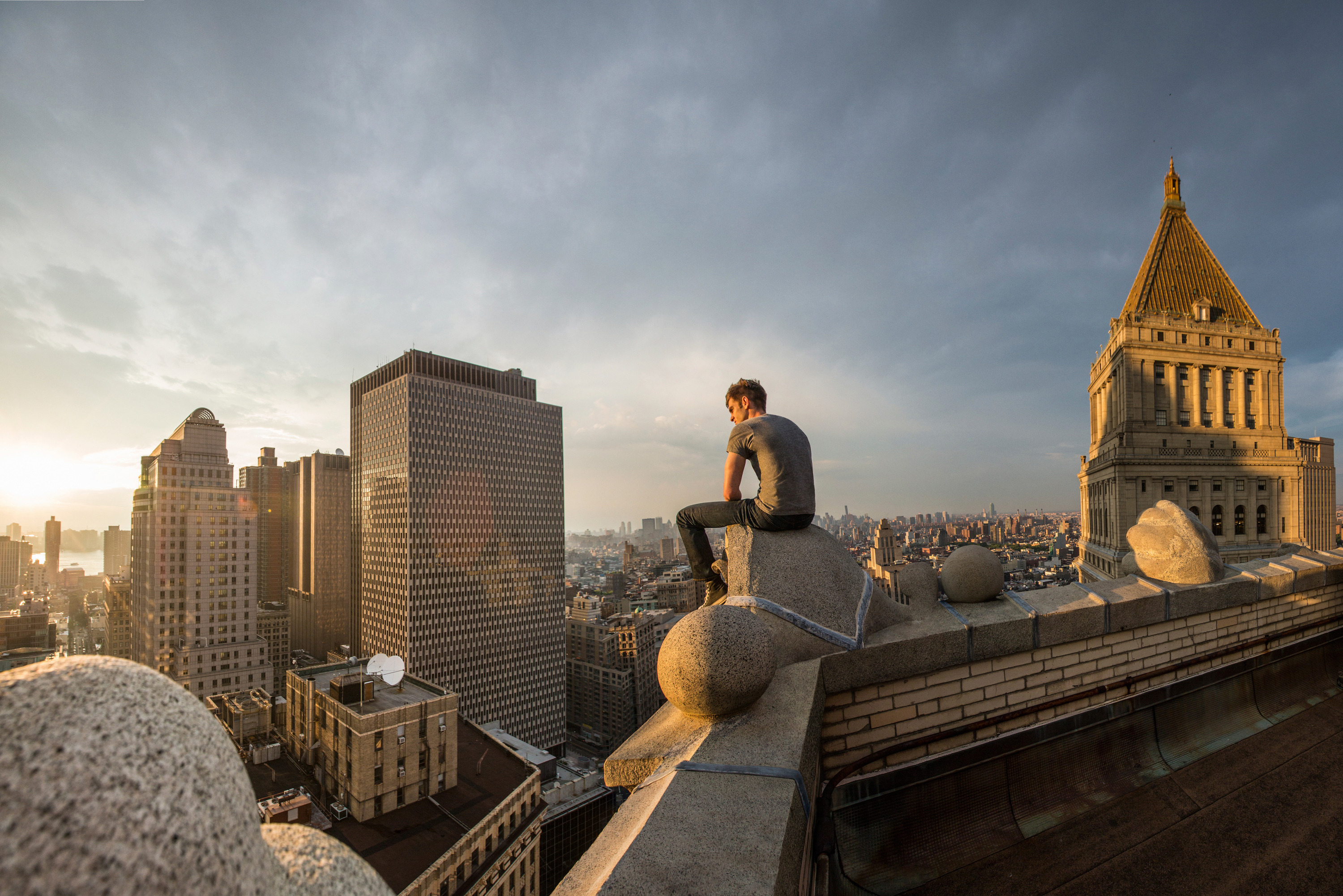 Man Sitting On Rock New York Skyscraping Buildings Image Download