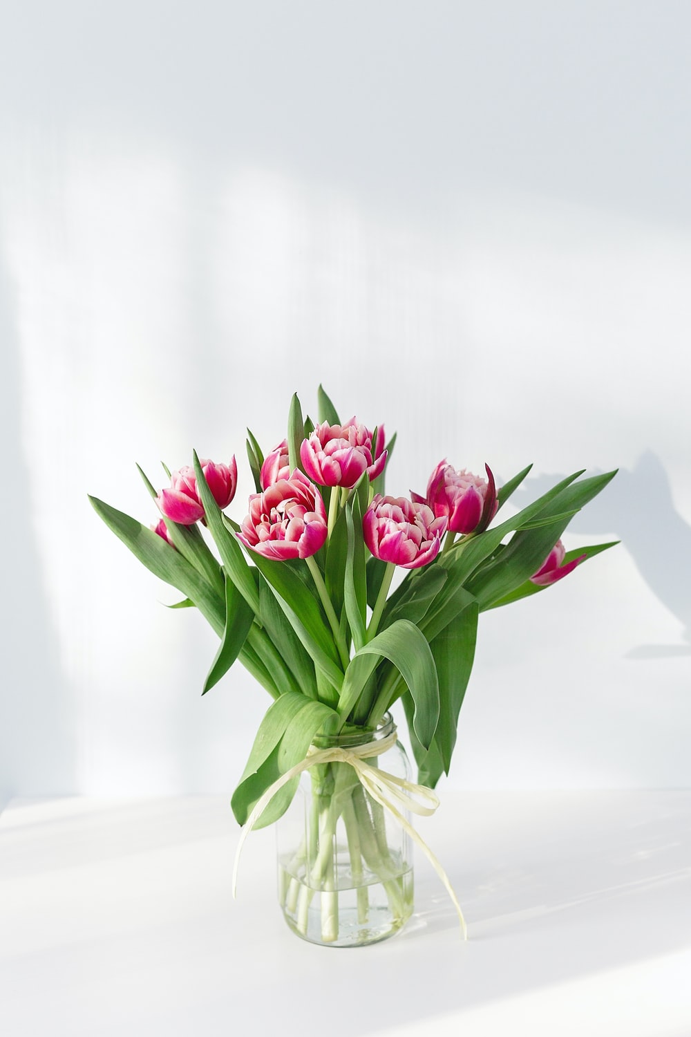 pink petaled flower centerpiece in clear glass vase photo