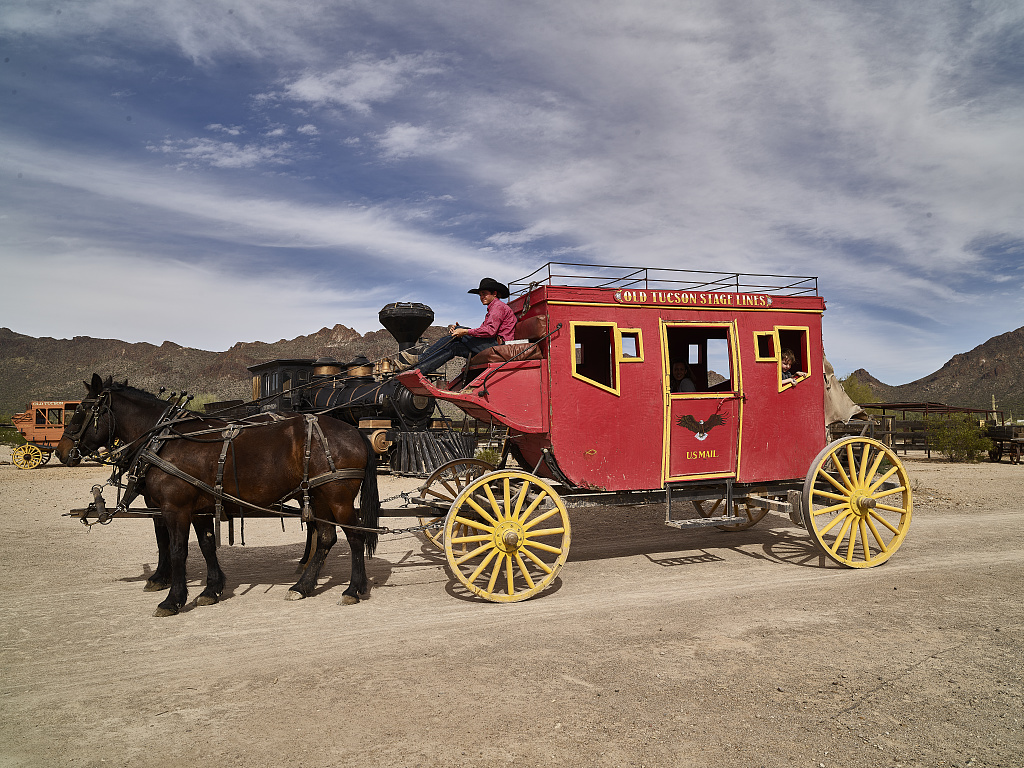 Stagecoach, horses, and driver at Old Tucson, a movie studio and theme park just west of Tucson, Arizona. Stage coach driver Colton Slaughter drives the stage coach pulled by horses Thimble (left)