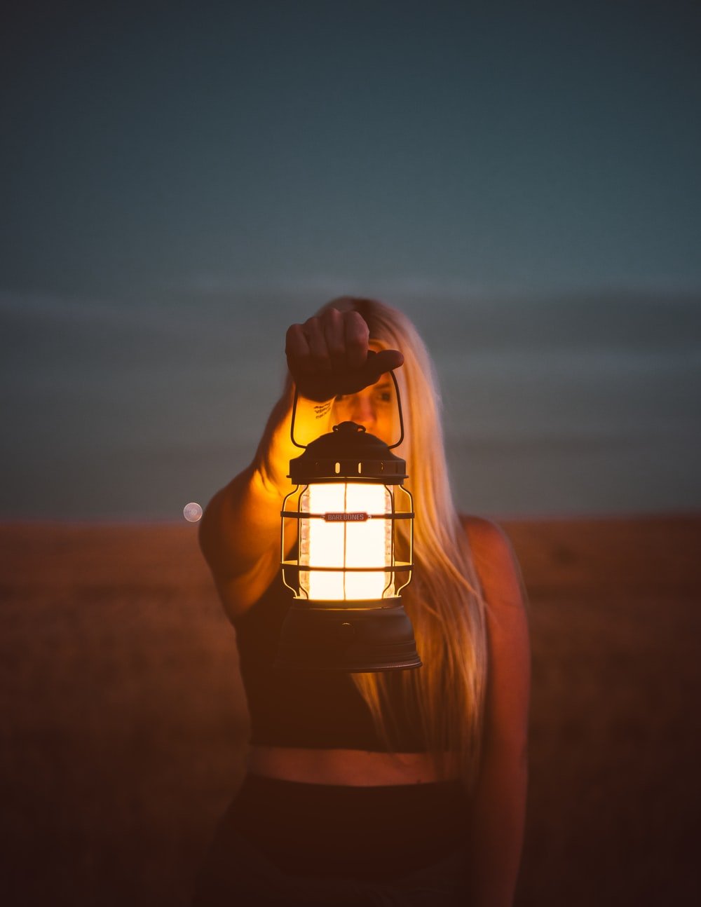 shallow focus photography of woman holding lantern photo