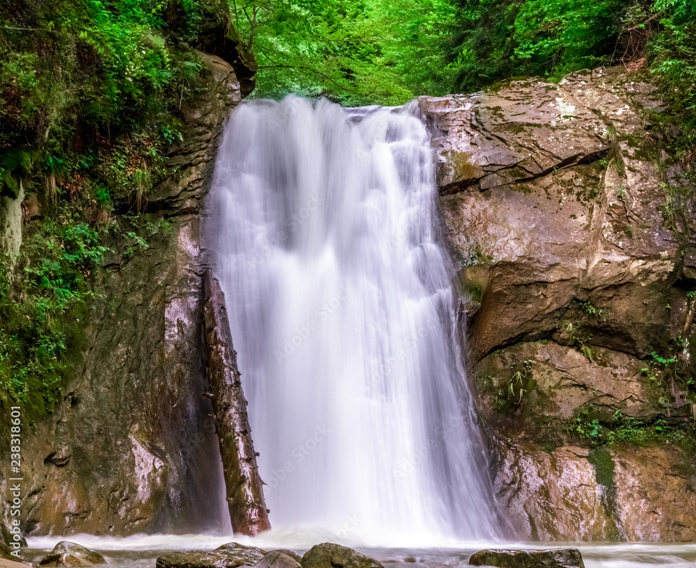 spring nature background. springtime scenery, wilderness landscape wallpaper with waterfall, cascade on long exposure, rocks and green vegetation in spring. outdoors, beauty in nature