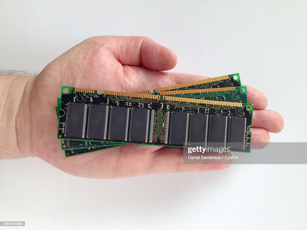 Cropped Hand Of Man Holding Random Access Memories Against White Background High Res