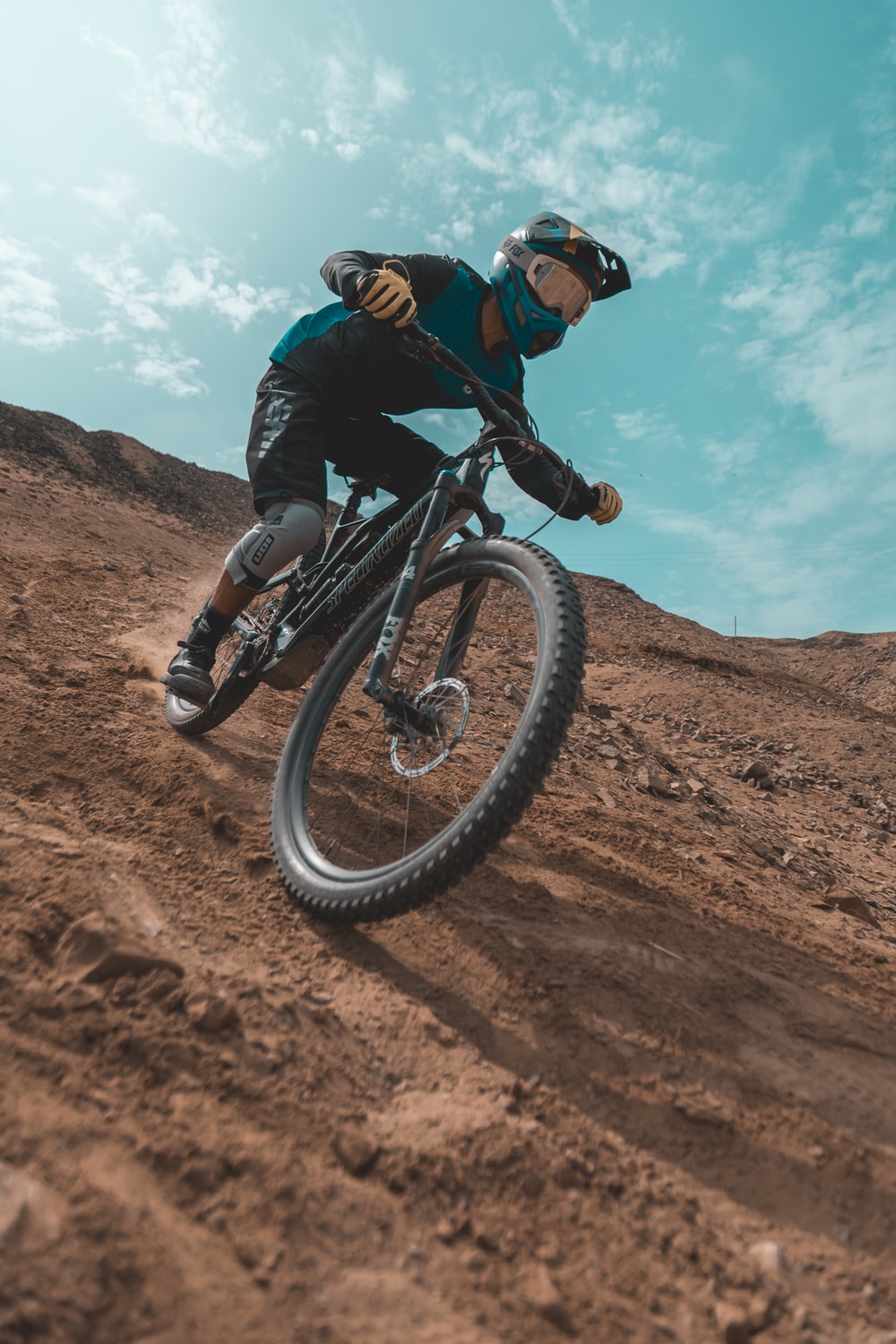 man in black jacket riding on black mountain bike on brown field during daytime photo