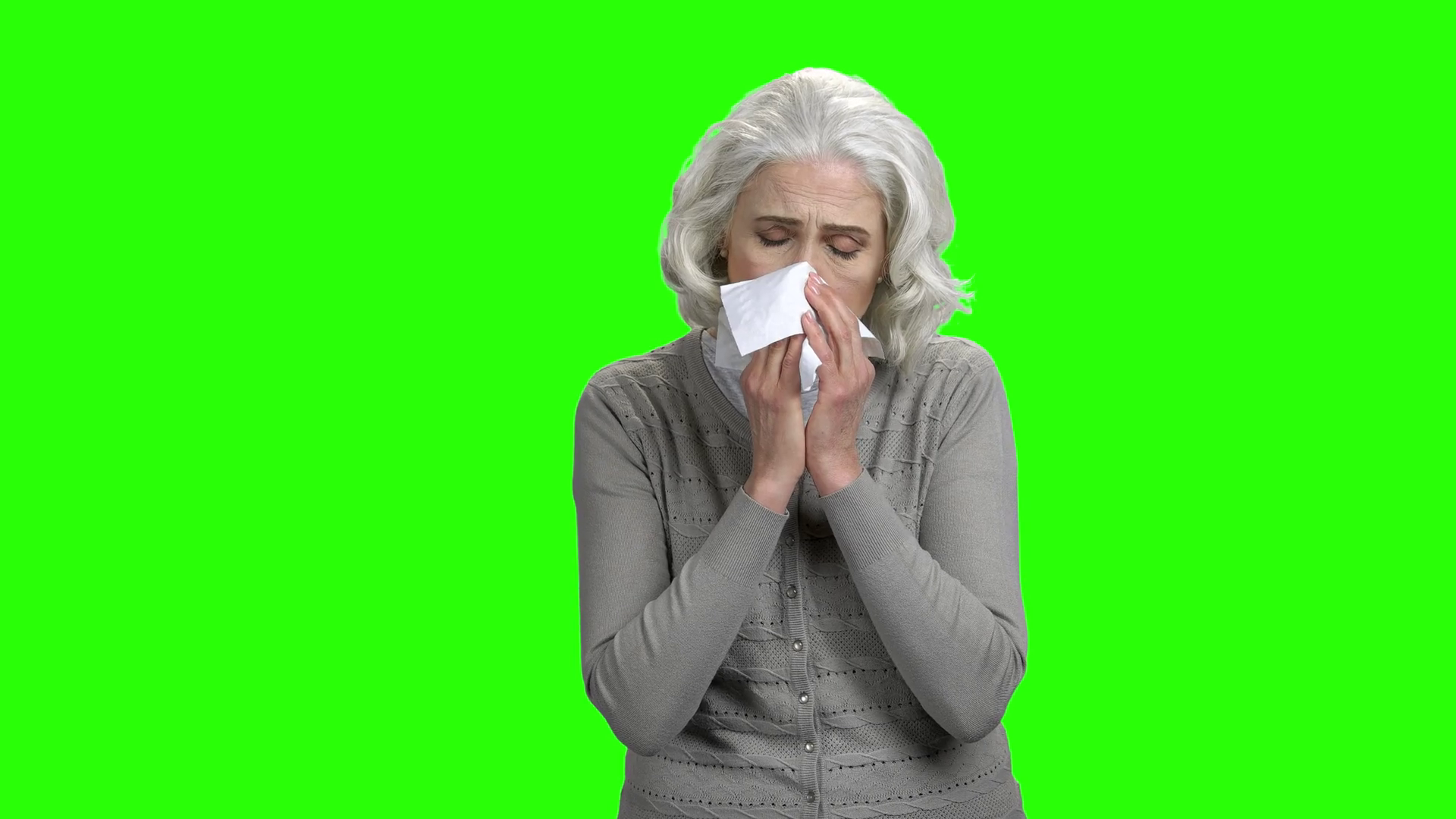 Sneezing caucasian woman on green screen. Sick elderly woman sneezing into paper tissue. Chroma key background for keying. Stock Video Footage