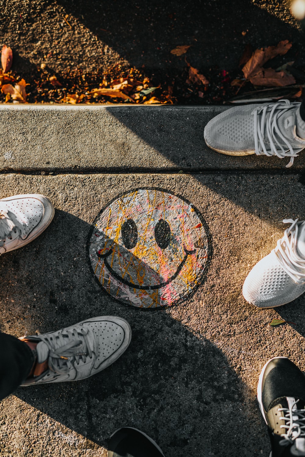 smiley paint on gray ground in front of people photo