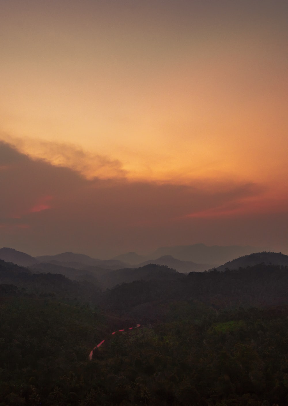 green mountains under orange sky photo