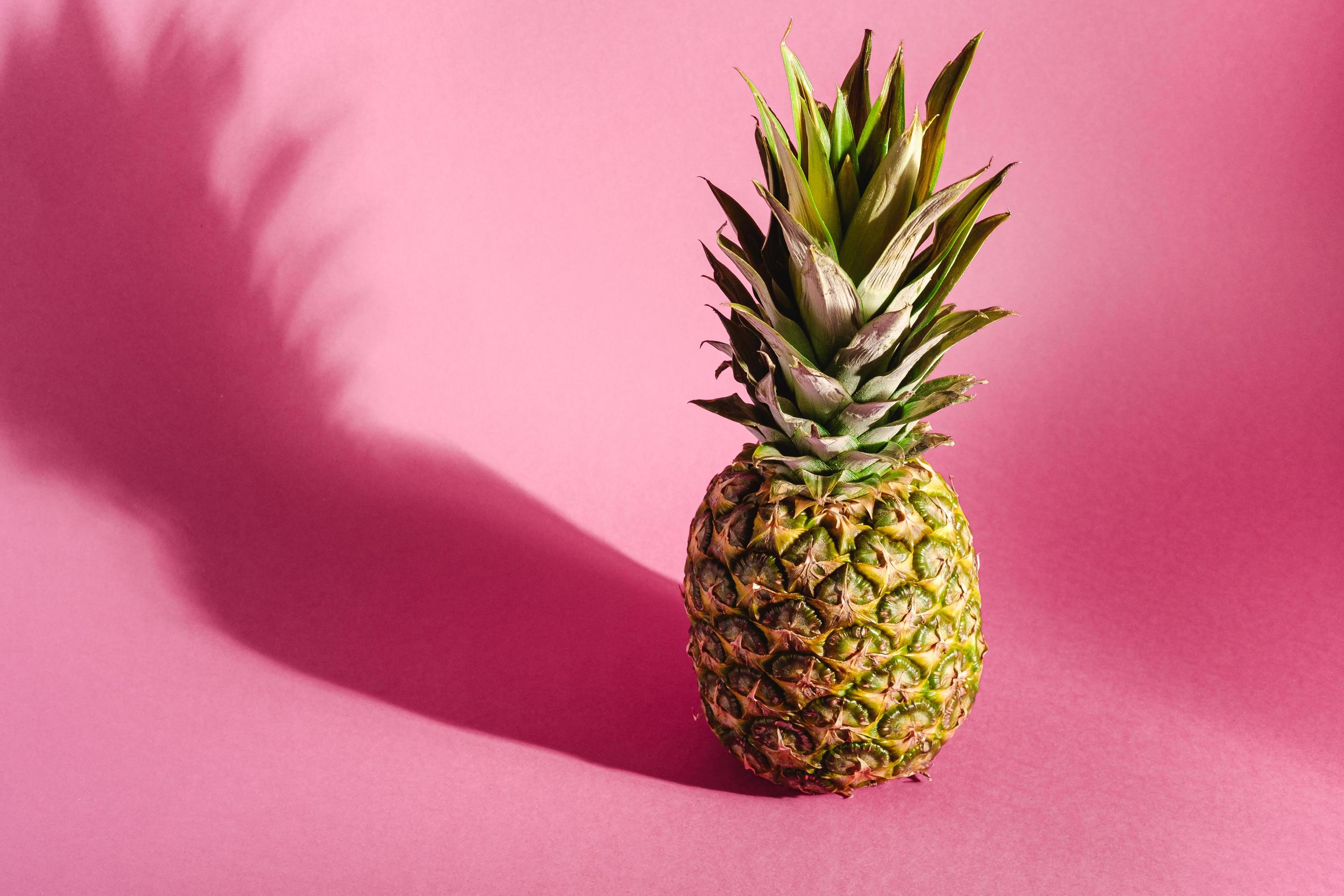 Pineapple on pink purple background with hard shadow