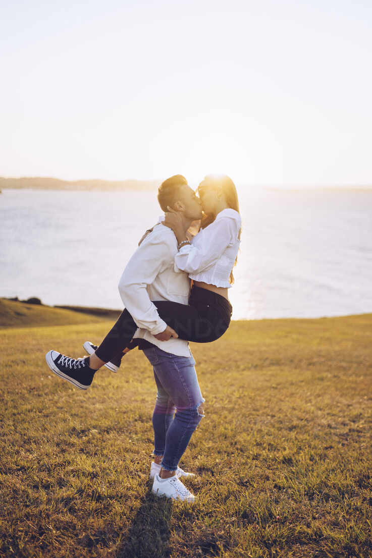 Boyfriend lifting girlfriend and kissing at Mirador de La Providencia, Gijon, Spain