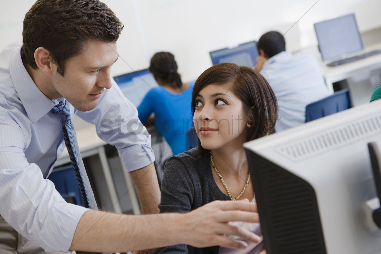 Teacher helping student in computer lab