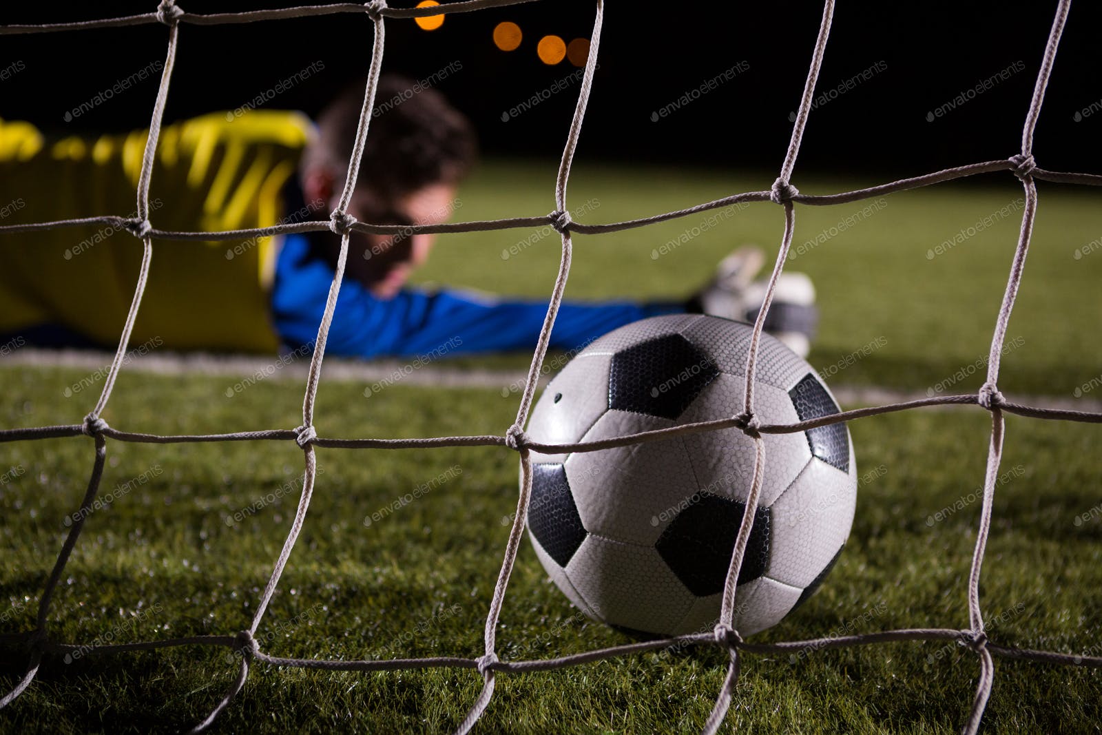 Close Up Of Soccer Ball In Goal Post Against Goalkeeper Photo By Wavebreakmedia On Envato Elements