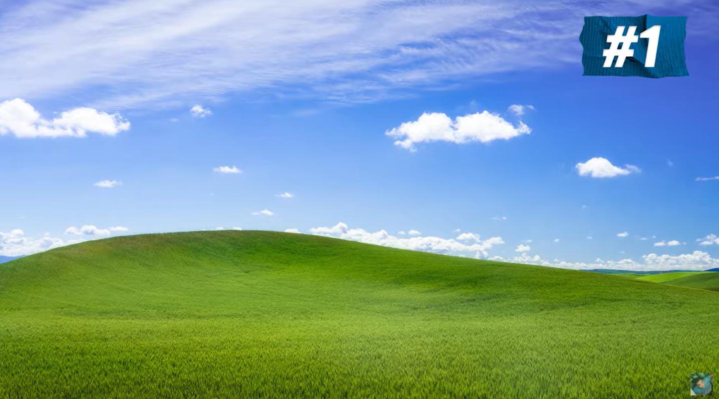 Three men recreate the classic Microsoft Windows XP wallpaper, the blue sky, white clouds and green grass remains