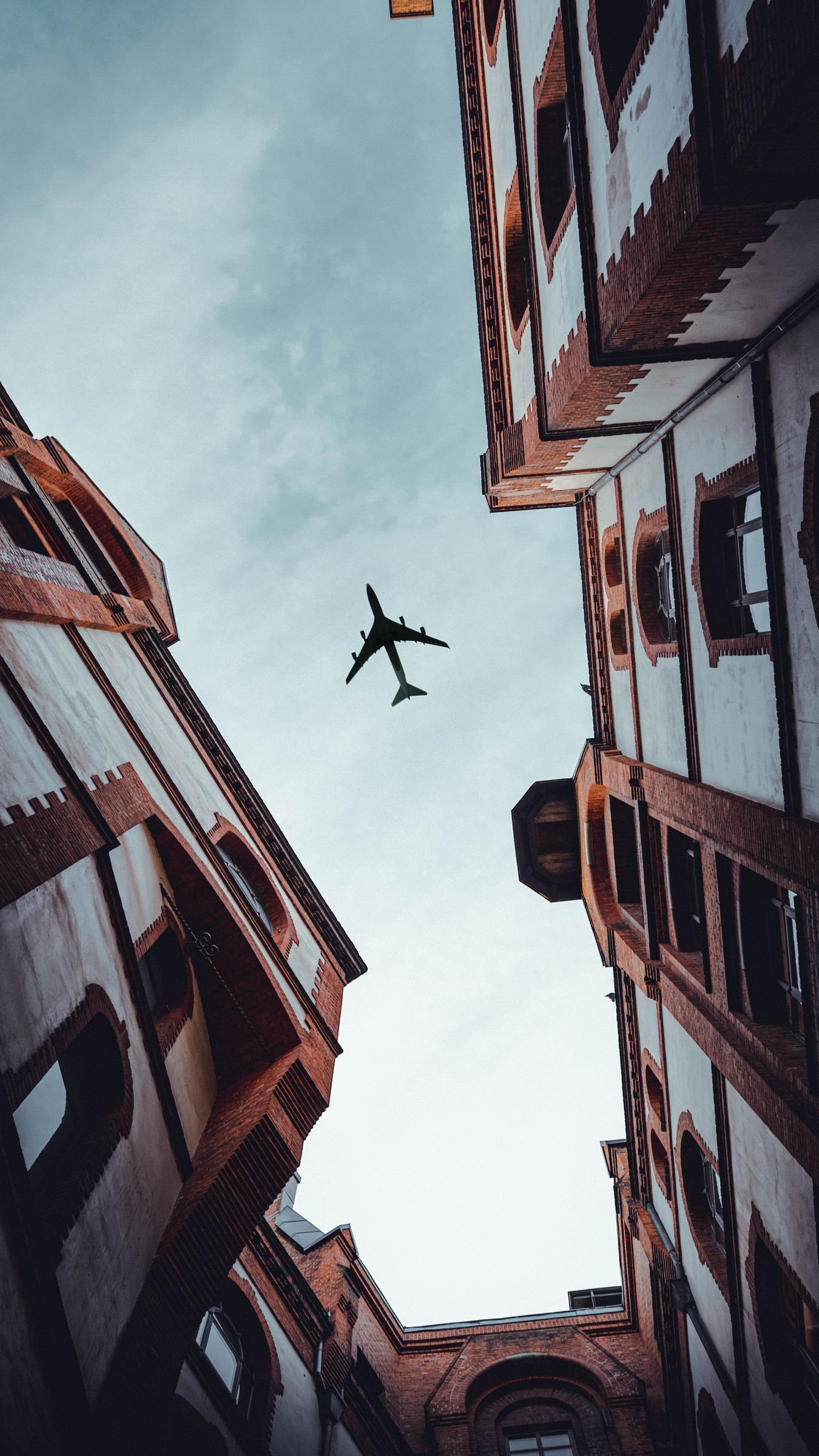 Download wallpaper 1350x2400 plane, view from below, building, flight, facade iphone 8+/7+/6s+/for parallax HD background