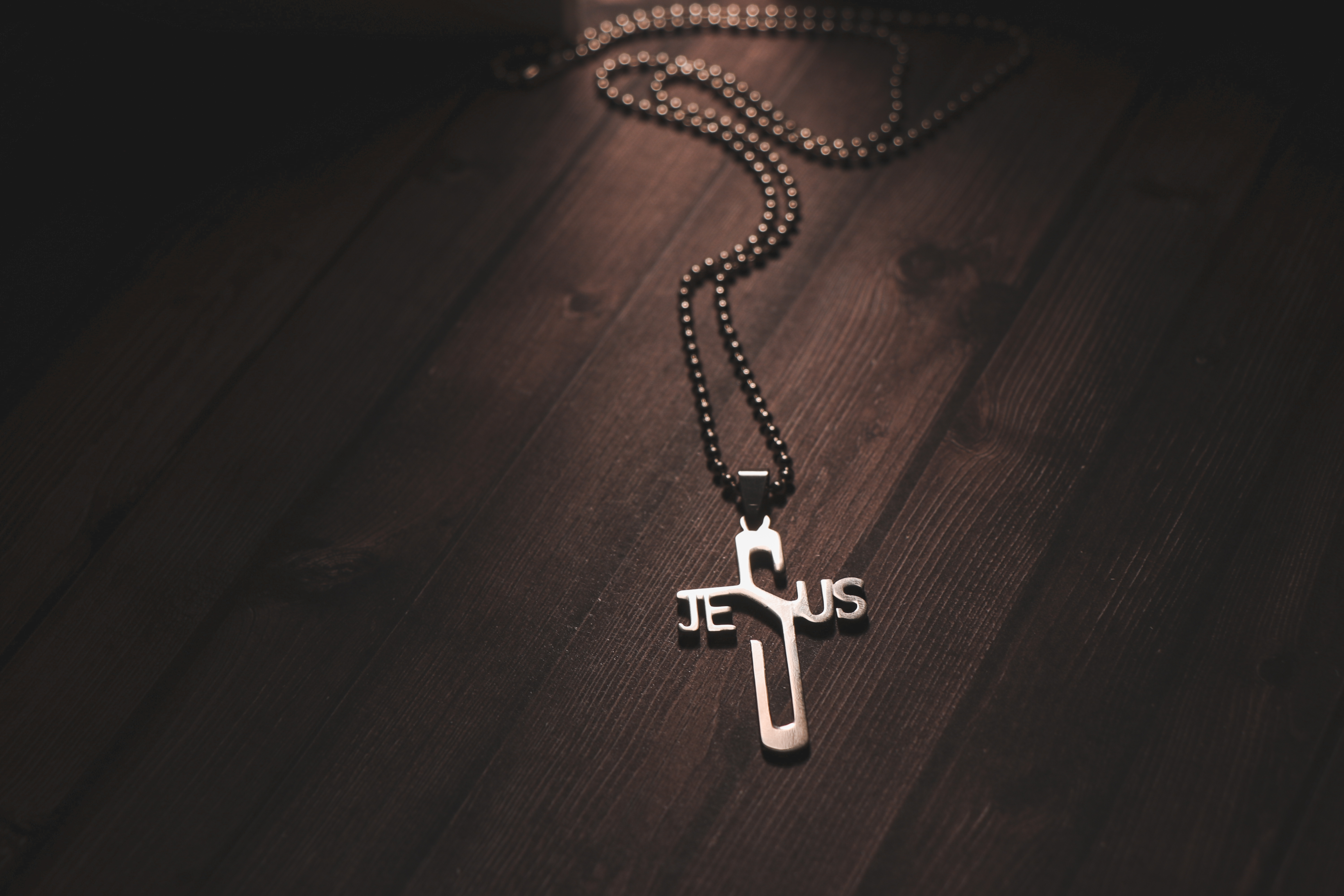 Necklace with Cross Pendant on Wooden Table · Free