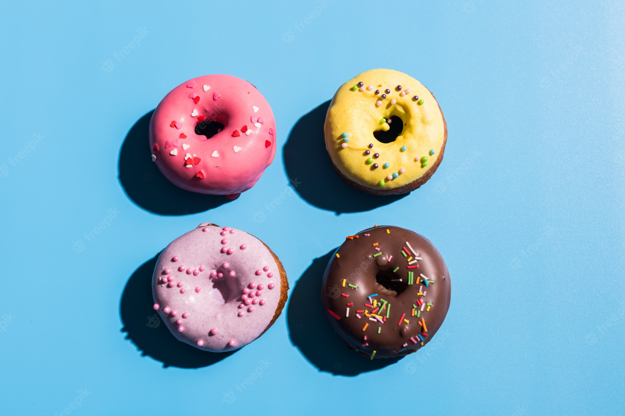 Premium Photo. Trendy sunlight. summer doughnuts on bright light blue turquoise background. minimal summer concept. pop art style. donut