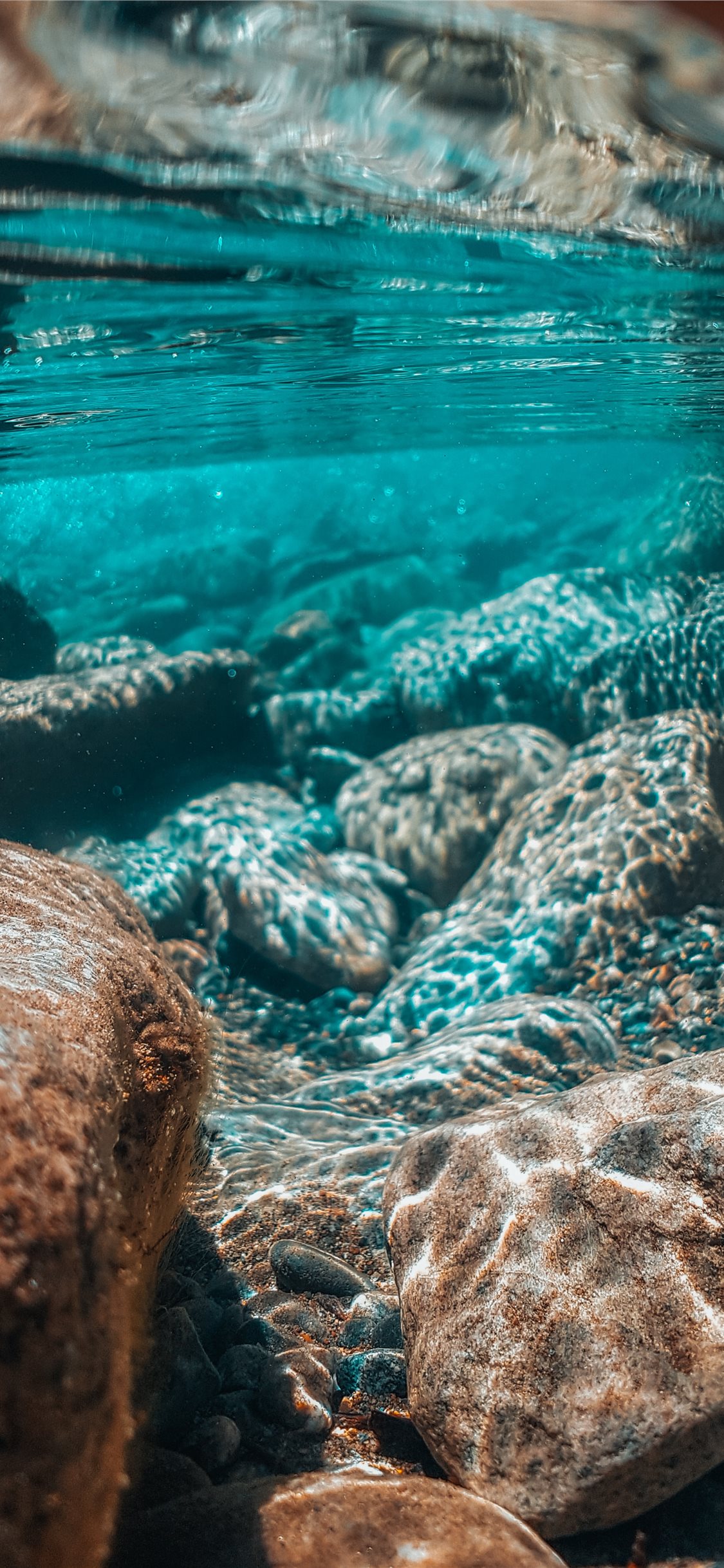 underwater photography of brown stones iPhone X Wallpaper Free Download