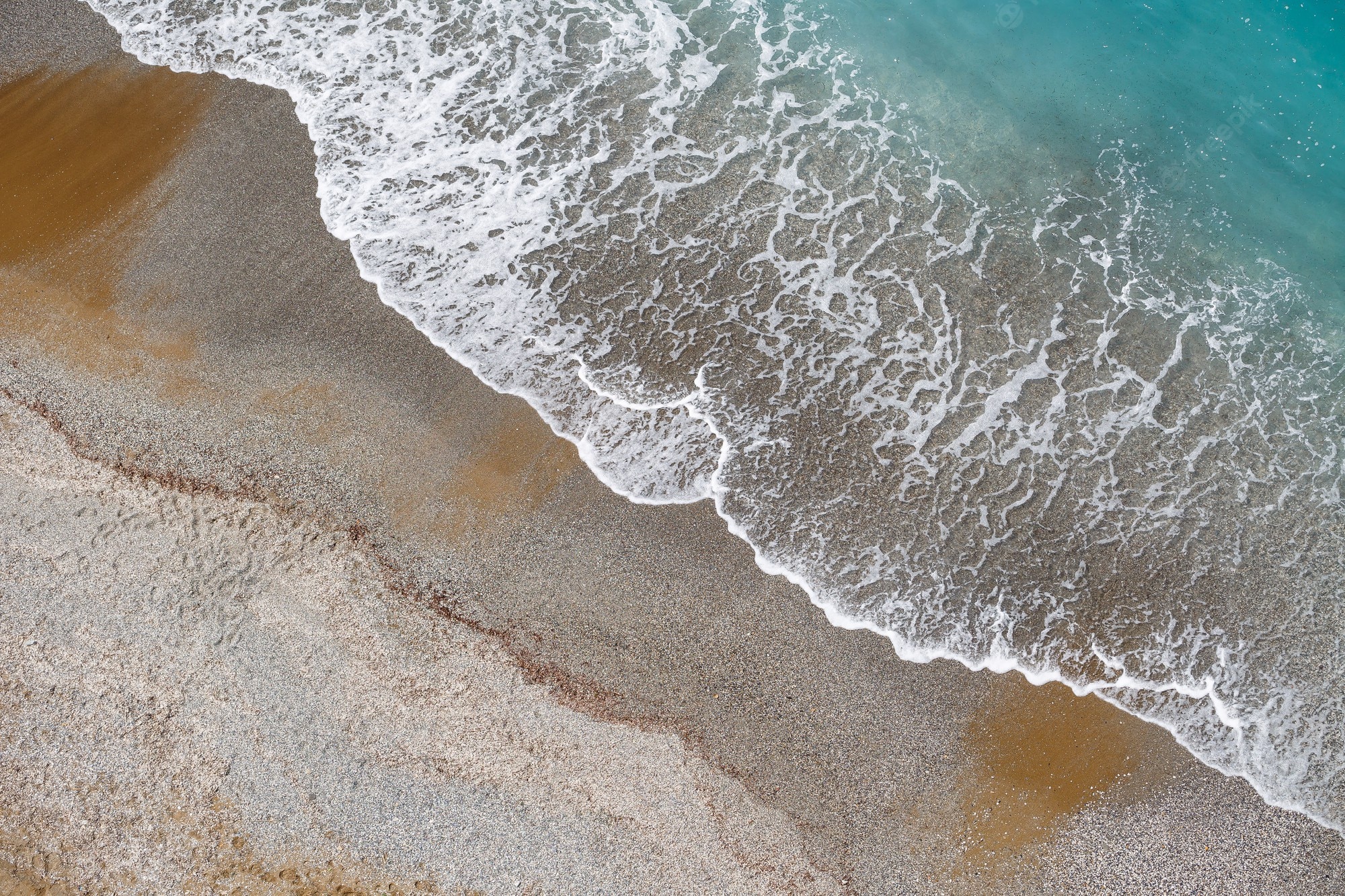 Premium Photo. Top view of the sea shore with azure water and a sandy beach. aerial view of the middle earth sea with coastline. beautiful tropical sea in summer season, shot