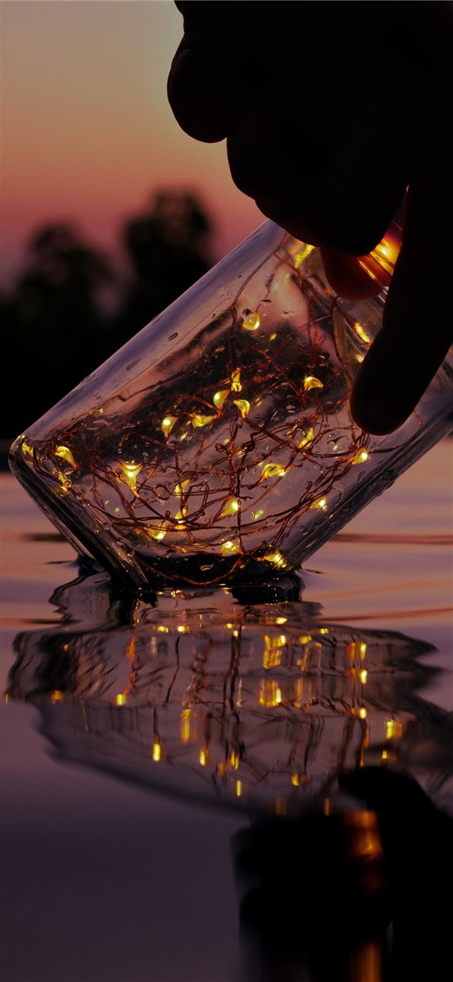 person holding string lights on clear glass jar ab. iPhone 11 Wallpaper Free Download