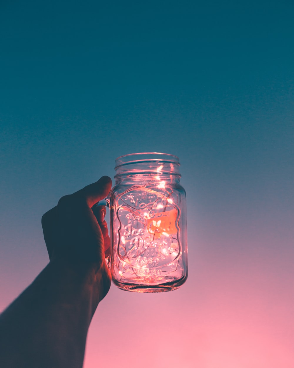 person holding clear glass mug jar photo