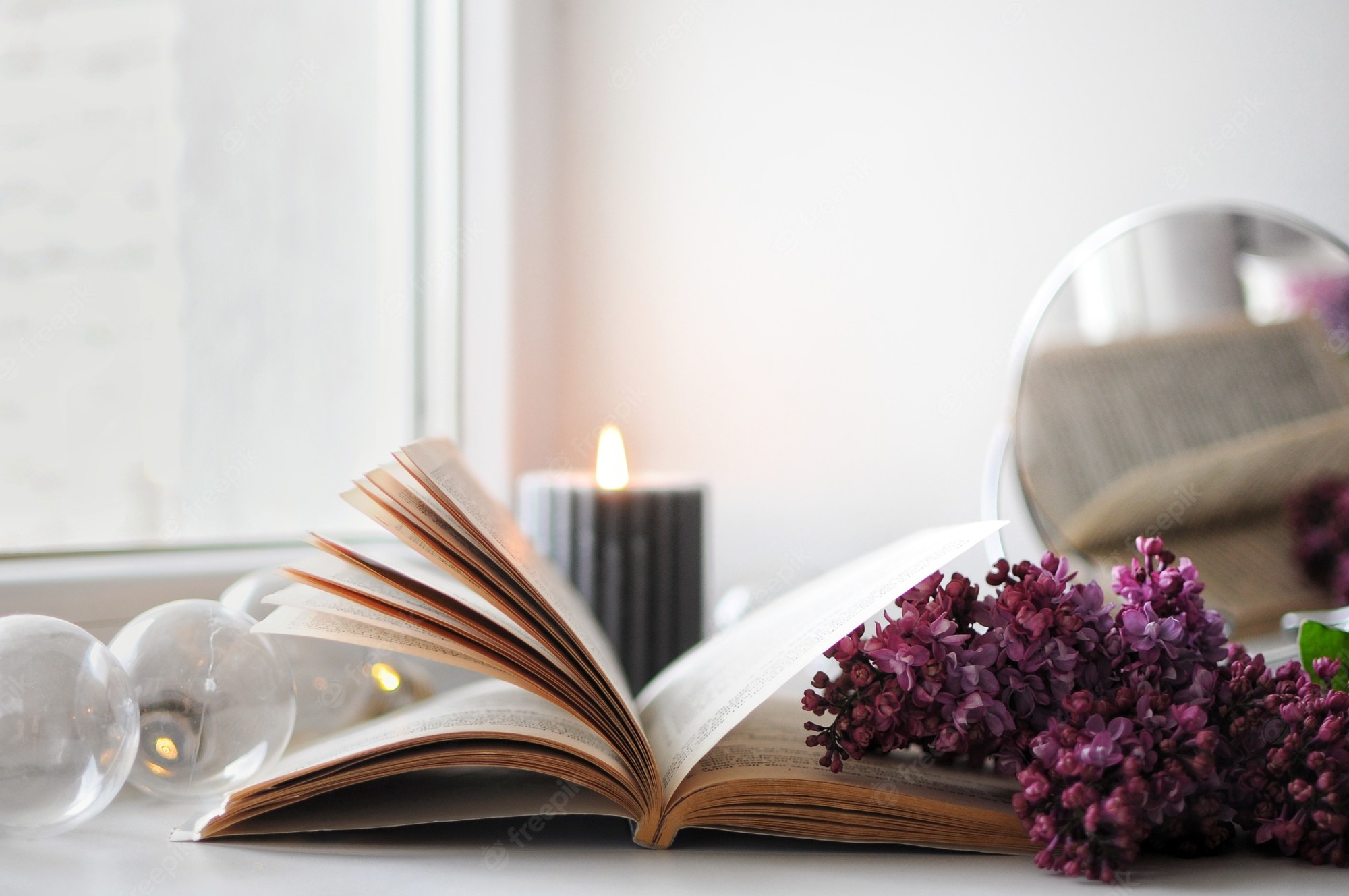 Premium Photo. Opened book with flowers. cozy spring atmosphere at home. blooming lilac with candle