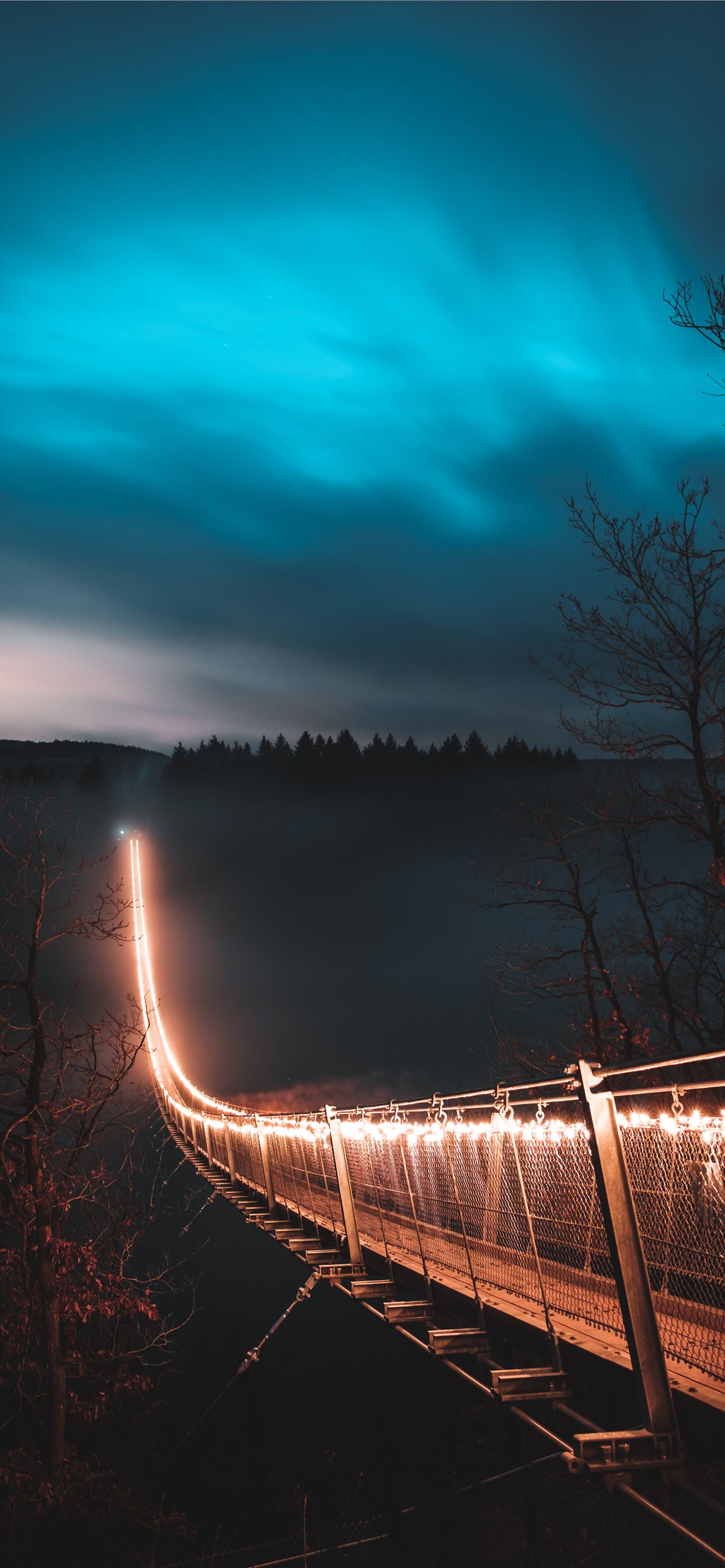 brown suspension bridge with light during nighttim. iPhone Wallpaper Free Download