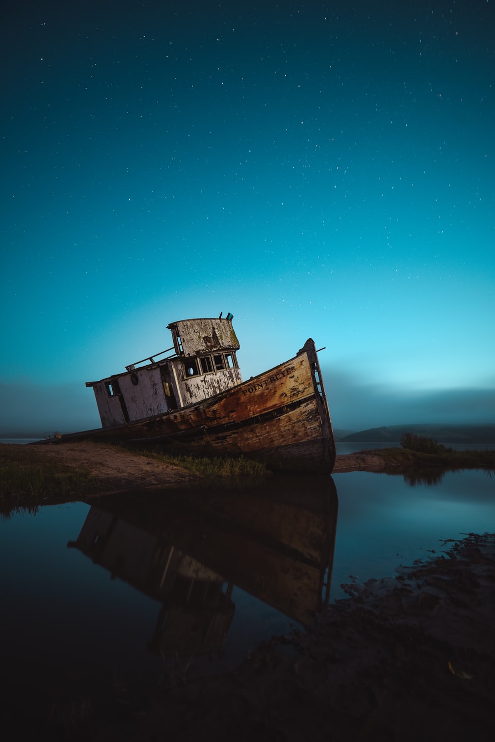 abandoned ship on seashore under sky with stars photo