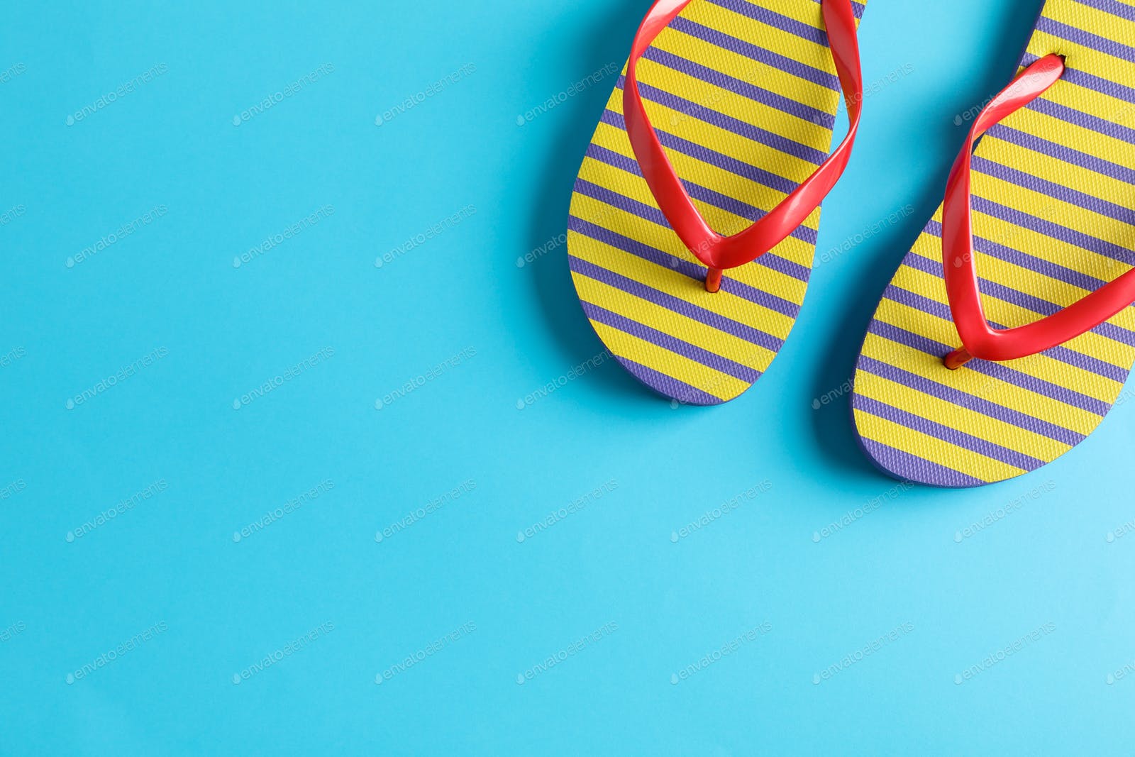 Flip flops on color background, space for text. Summer vacation backdrop photo by AtlasComposer on Envato Elements