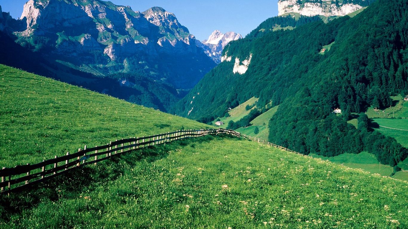 Download wallpaper 1366x768 fence, mountains, slopes, meadows, greens, pasture, trees, switzerland tablet, laptop HD background