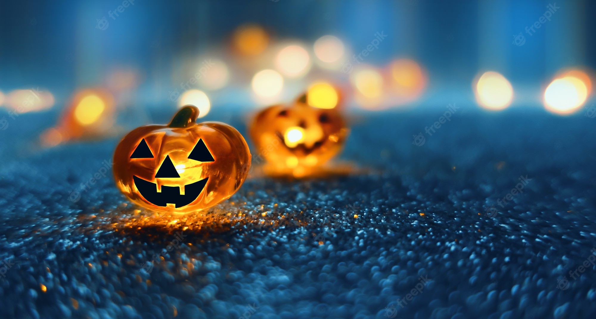 Premium Photo. Neon glowing pumpkin head on abstract blurred bokeh background. festive halloween background with cobwebs and pumpkin