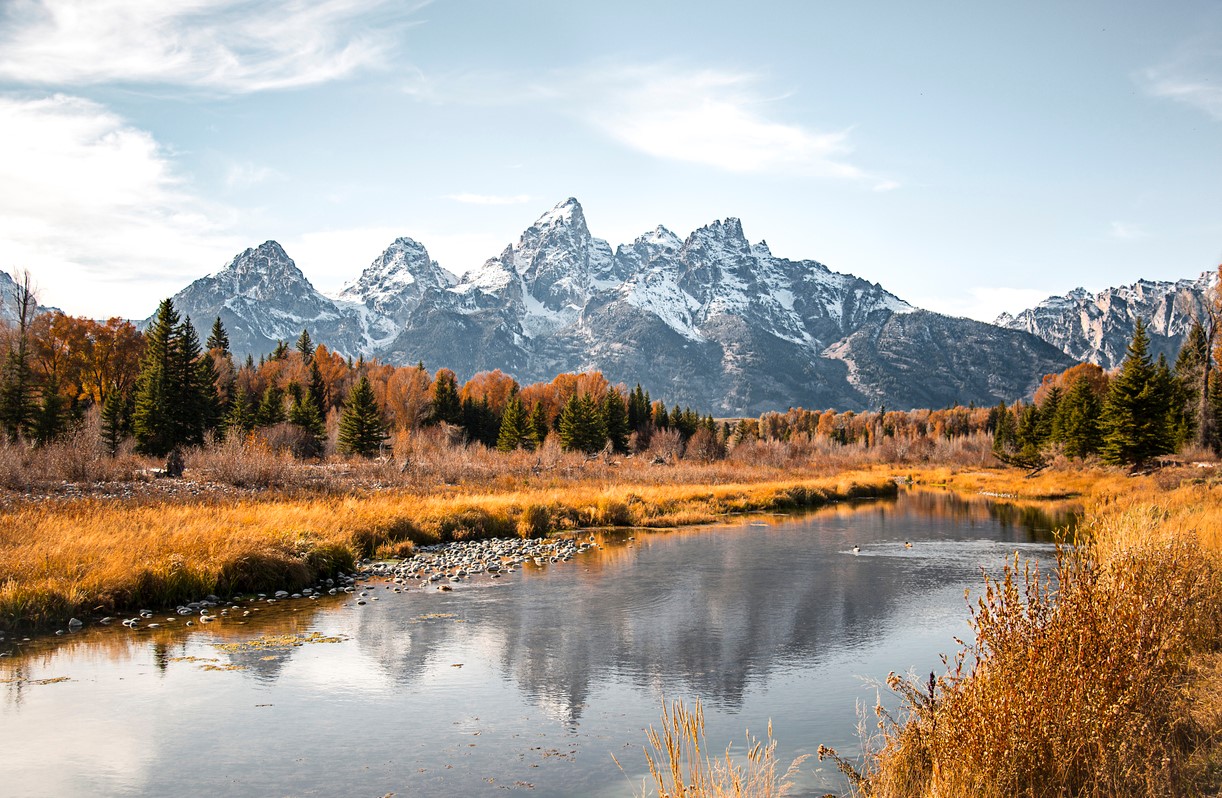 Teton mountain range reflection in the Snake River at Schwabacher's Landing in Grand Teton National Park, Wyoming. Fall scenic nature landscape with evergreen trees and a mountain water reflection