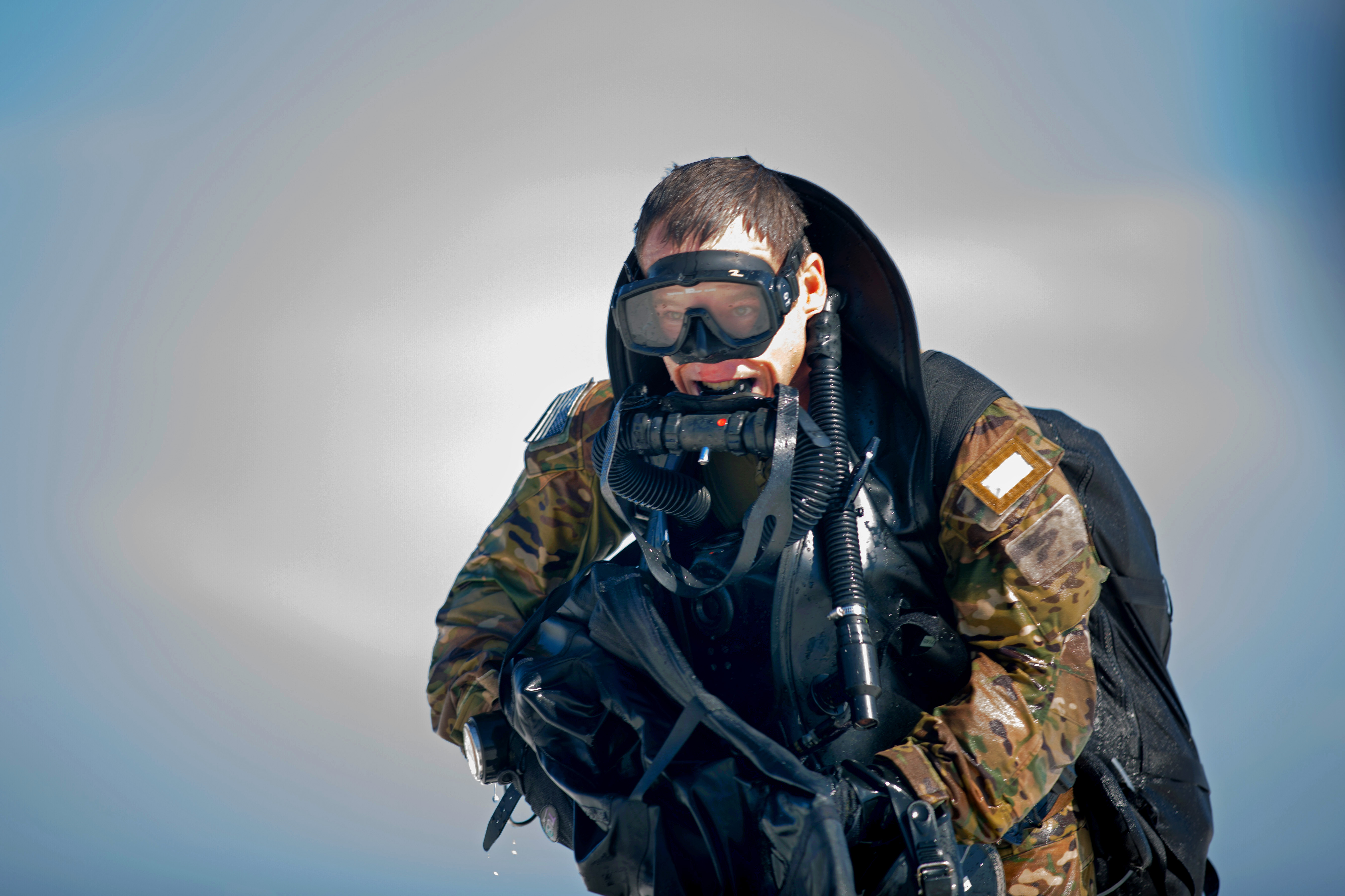 An Army Green Beret moves onto a beach to link up with other team members before