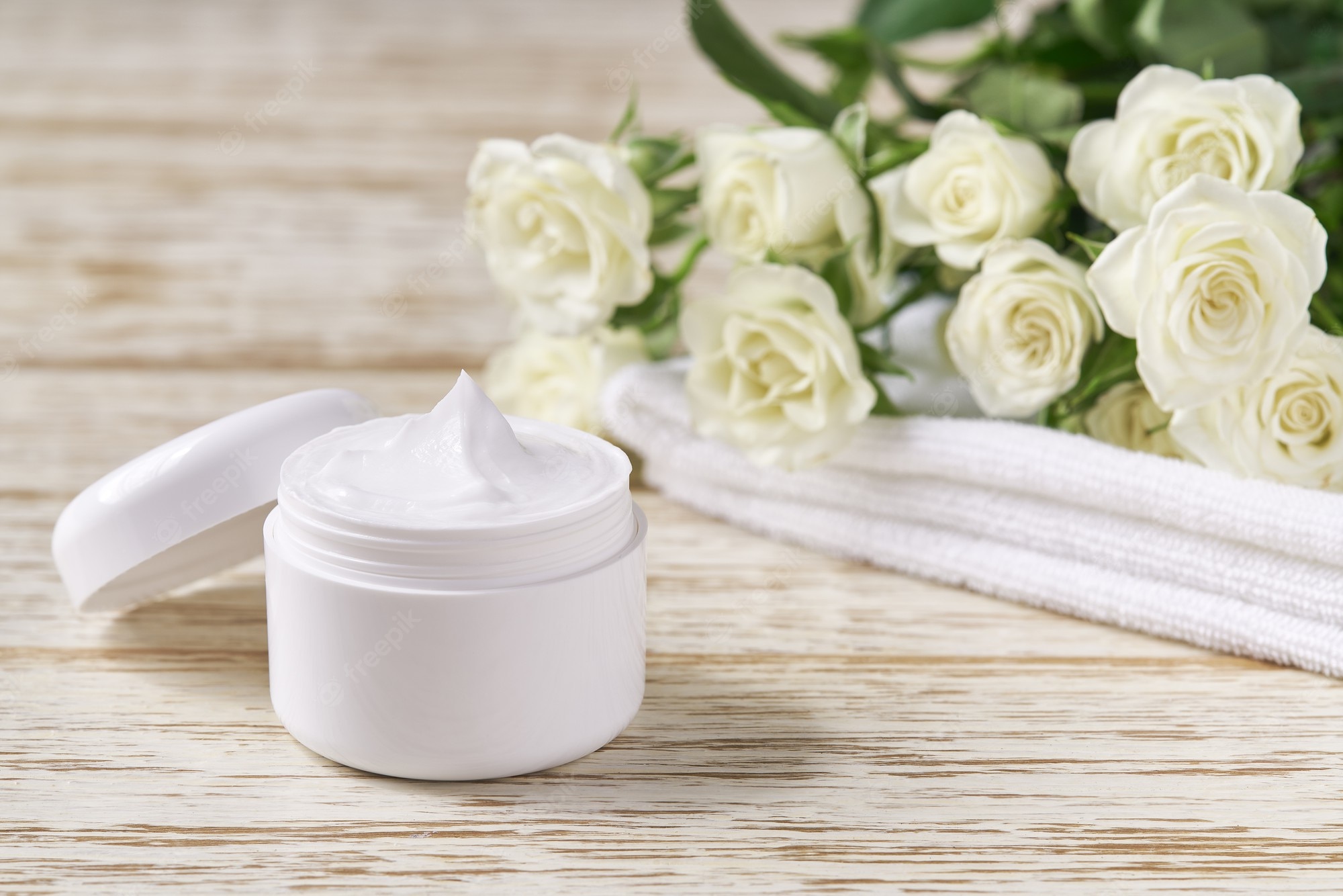 Premium Photo. Natural face cream or lotion sensitive skin, organic cosmetic product to moisturize the skin on a background of white roses. skin cleansing cosmetic luxury cream or vitamin spa lotion