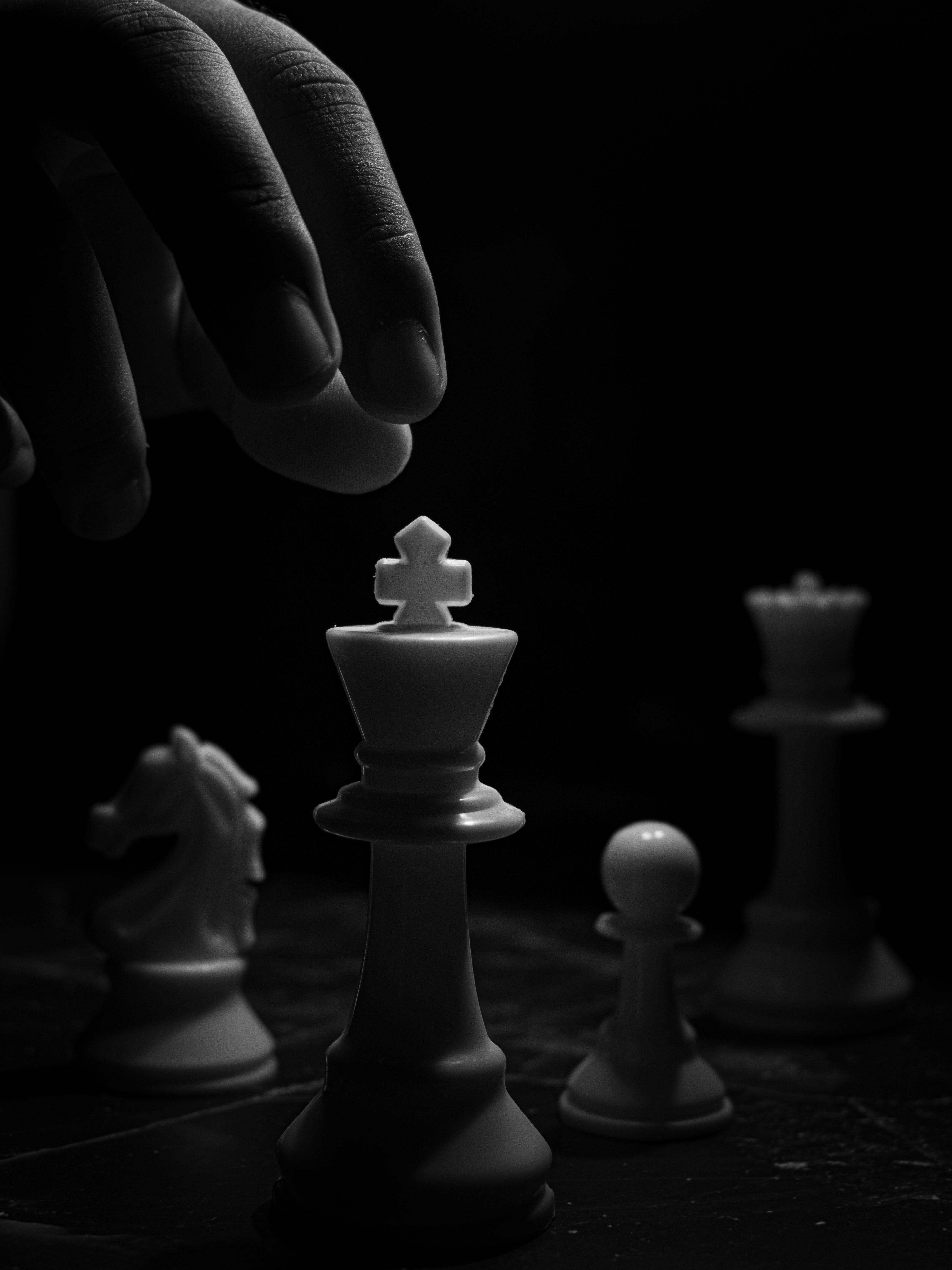 Grayscale Photo of Person Holding Chess Piece · Free