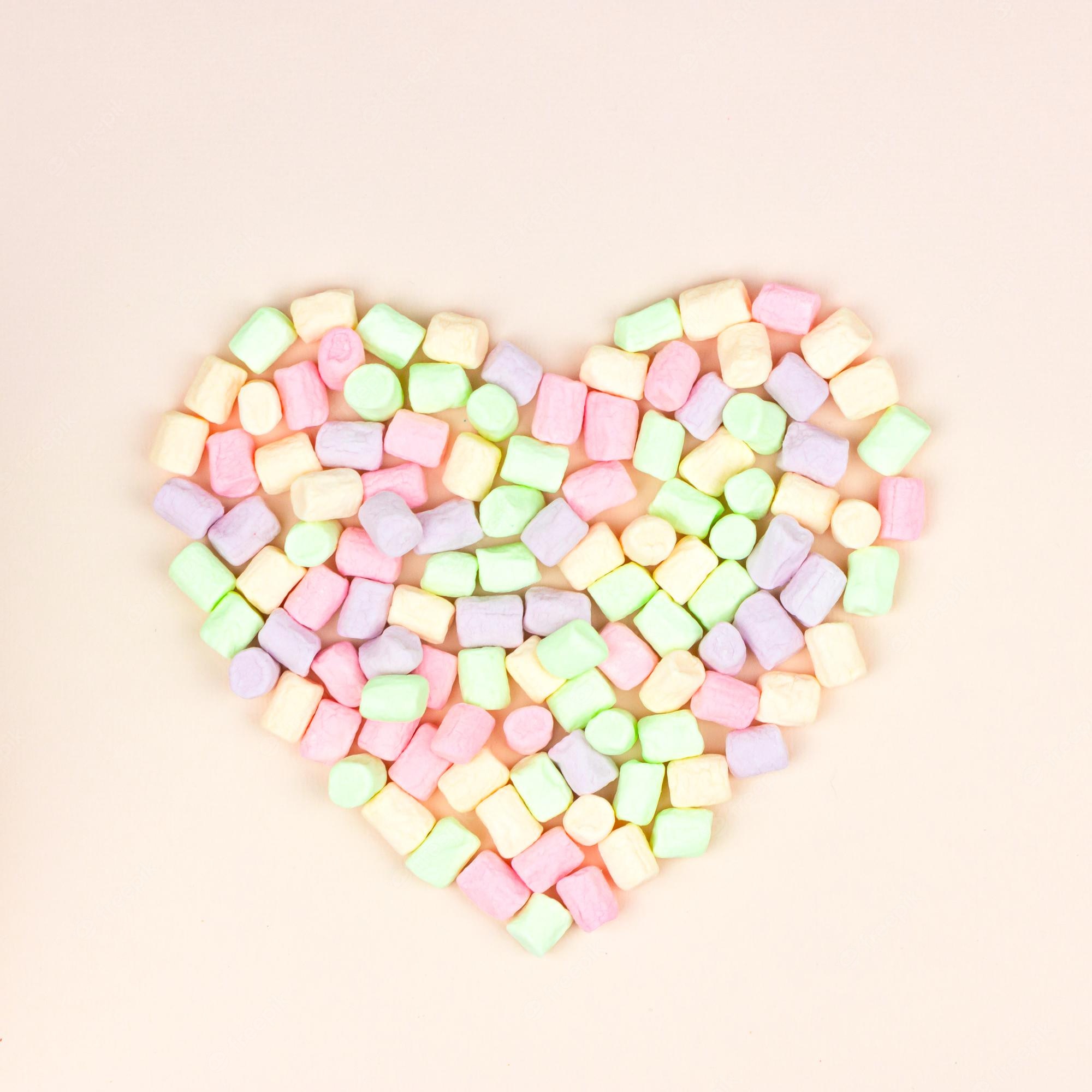 Premium Photo. Heart marshmallows background. top view, sweets and candy concept. pastel color dessert for background or wallpaper decor