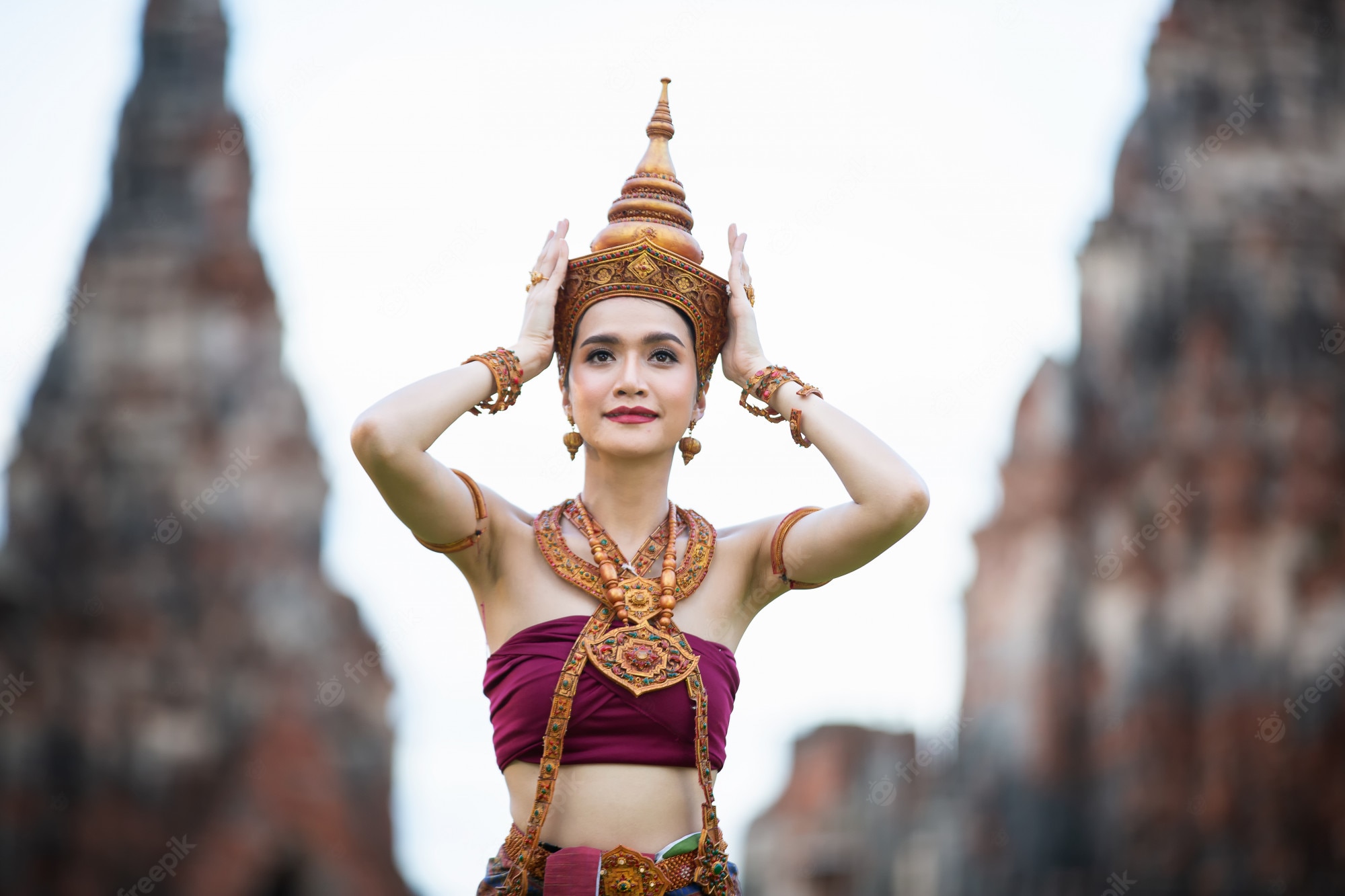 Premium Photo. Portrait of an asian women in thai traditional dancer clothes are standing against ancient buddha statue. ayuttaya historical park, thailand asia