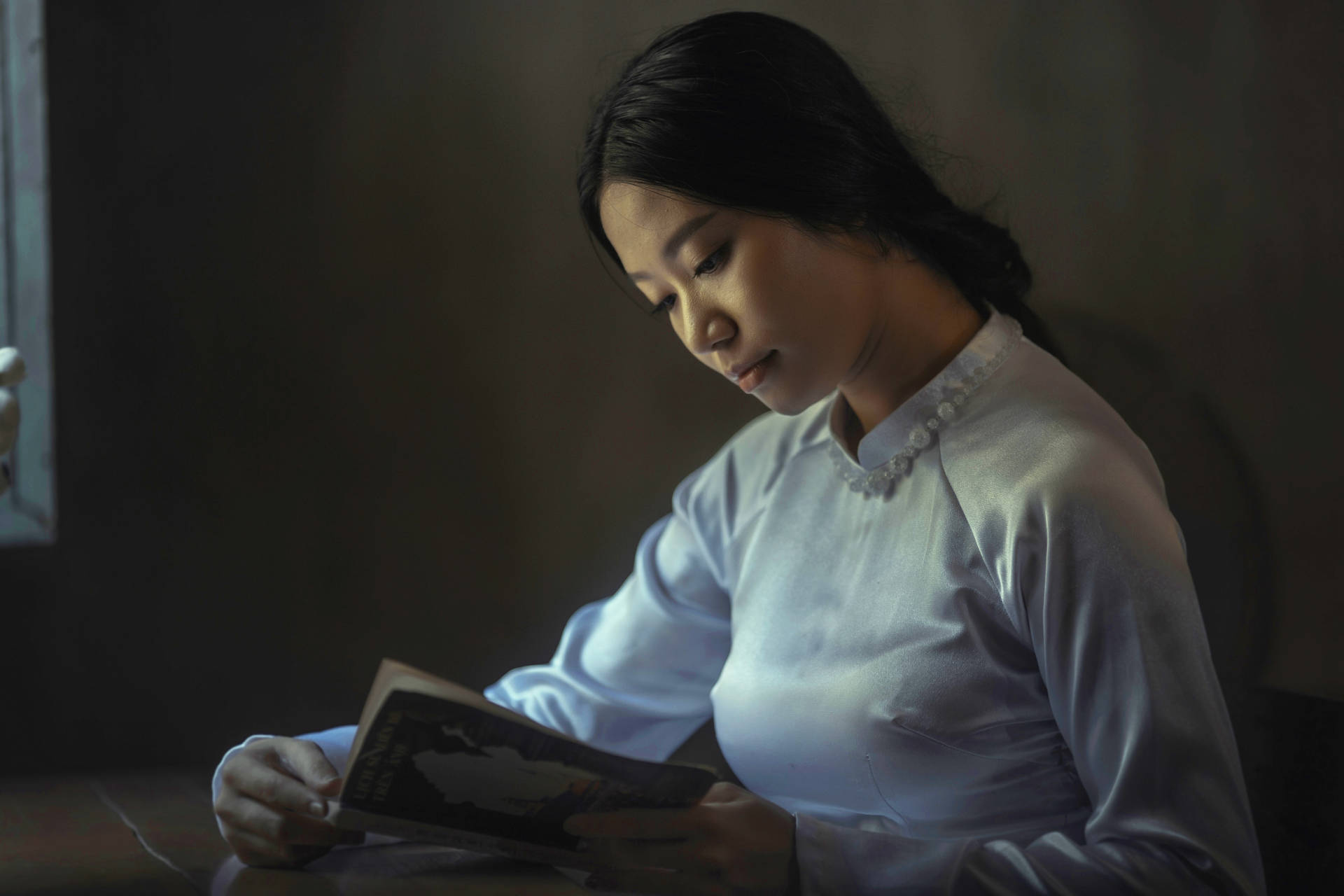 Download Black Haired Woman Reading Book Wallpaper