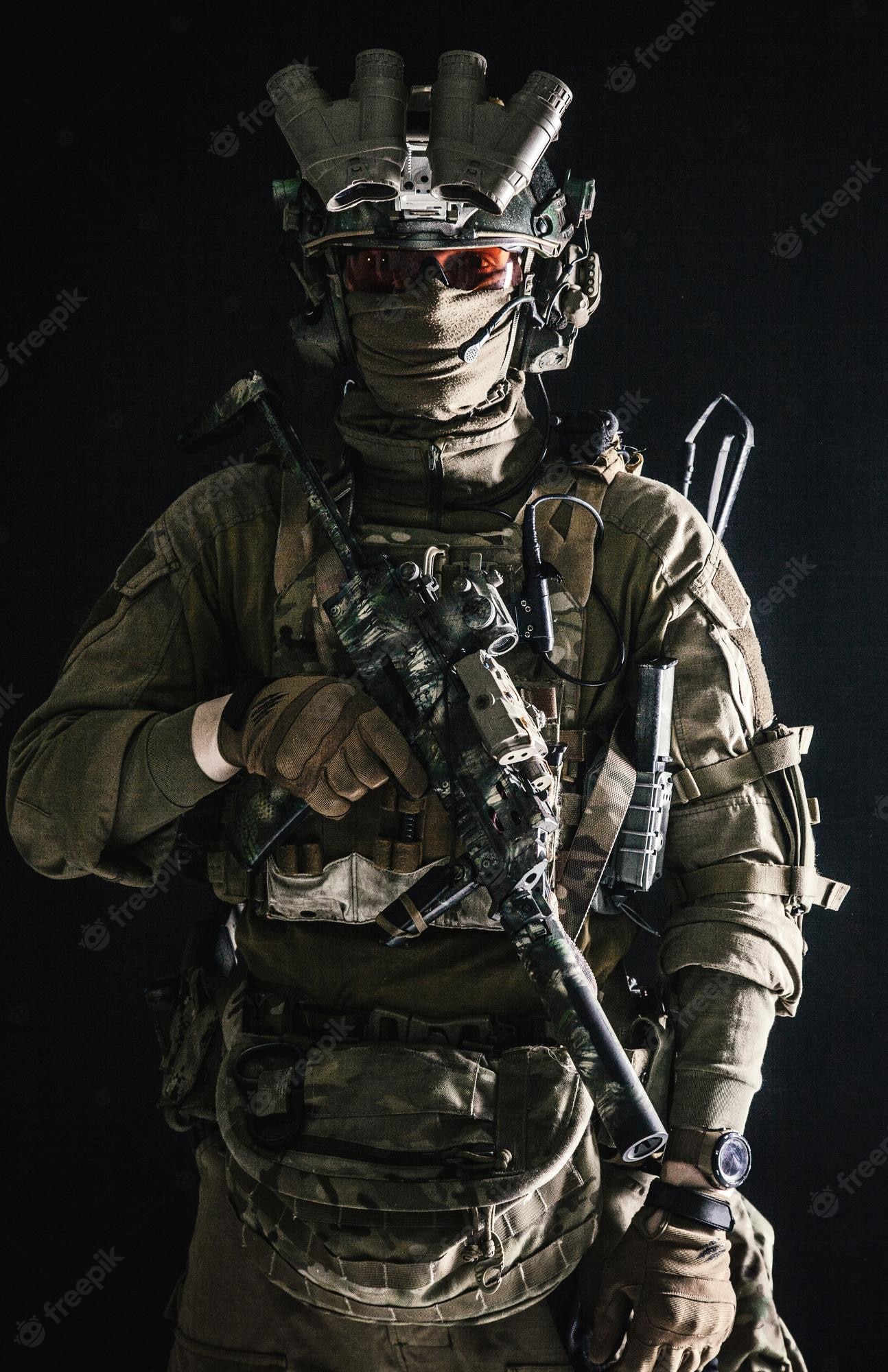 Premium Photo. Antiterrorist squad fighter army elite forces soldier in combat uniform and tactical ammunition armed mini submachine gun wearing nightvision device low key studio portrait on black background