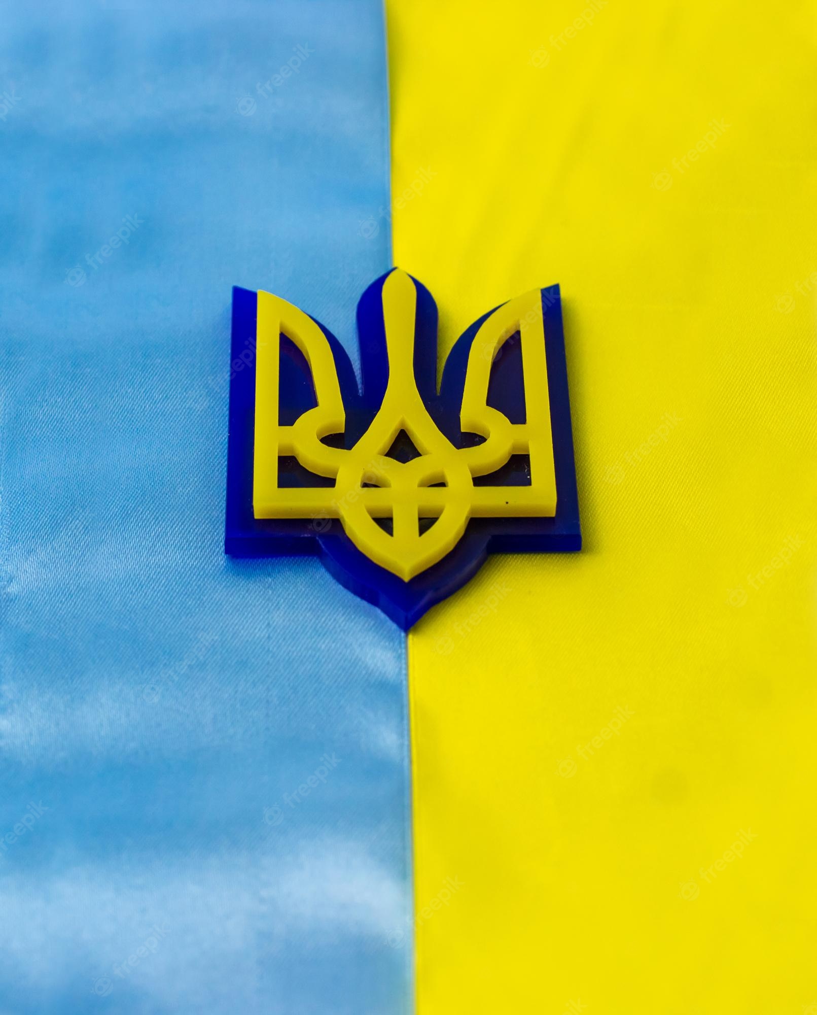 Premium Photo. Coat of arms of ukraine on the background of the flag flag of blue and yellow stripes
