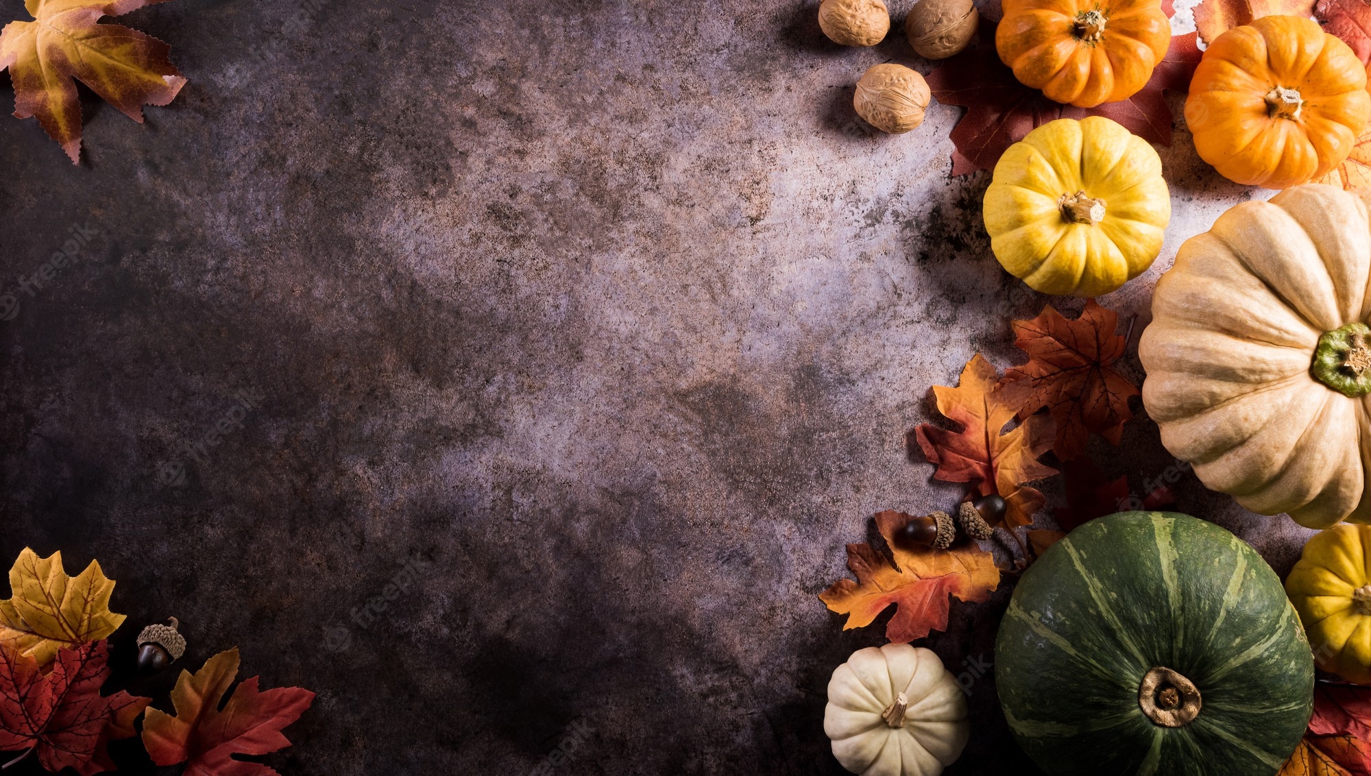 Premium Photo. Thanksgiving background concept with fall leaves, pumpkin and seasonal autumnal decor on dark stone background