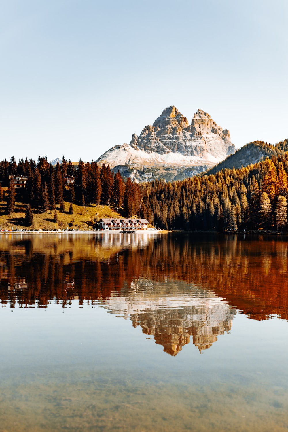 lake surrounded by trees and snow covered mountain during daytime photo