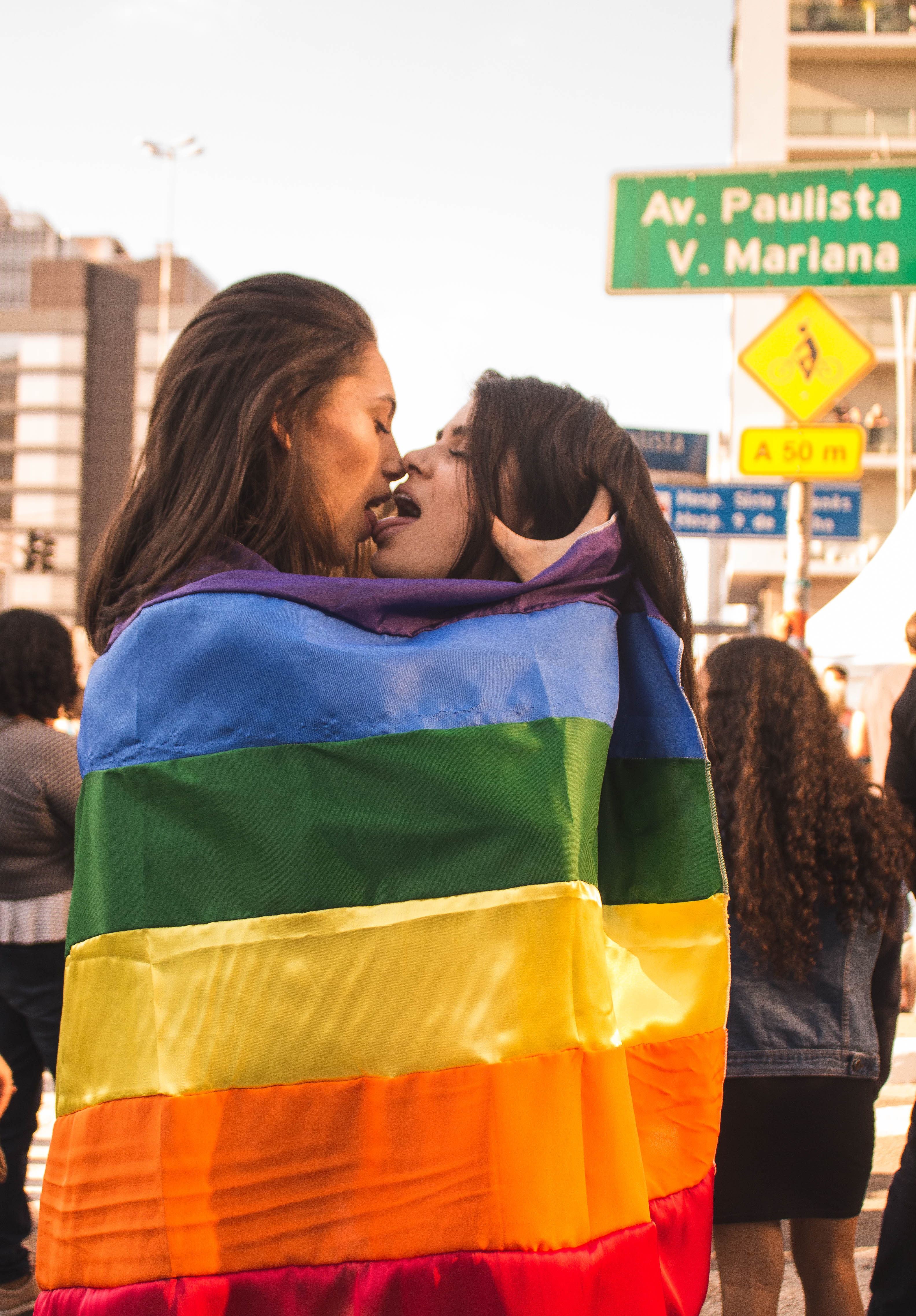 Two Women Kissing While Wrapped in Rainbow Flag · Free