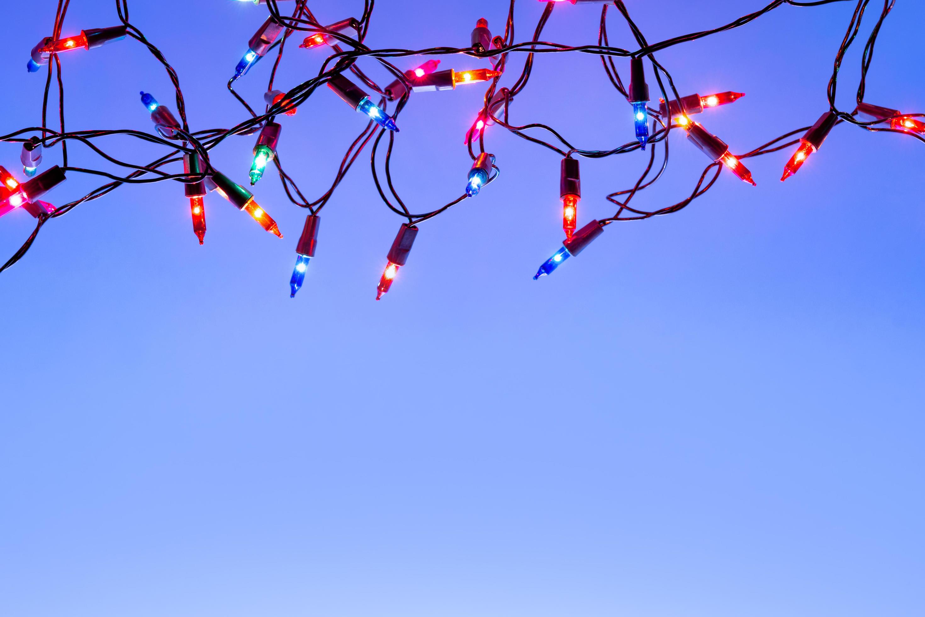 Christmas lights string on blue background with copy space